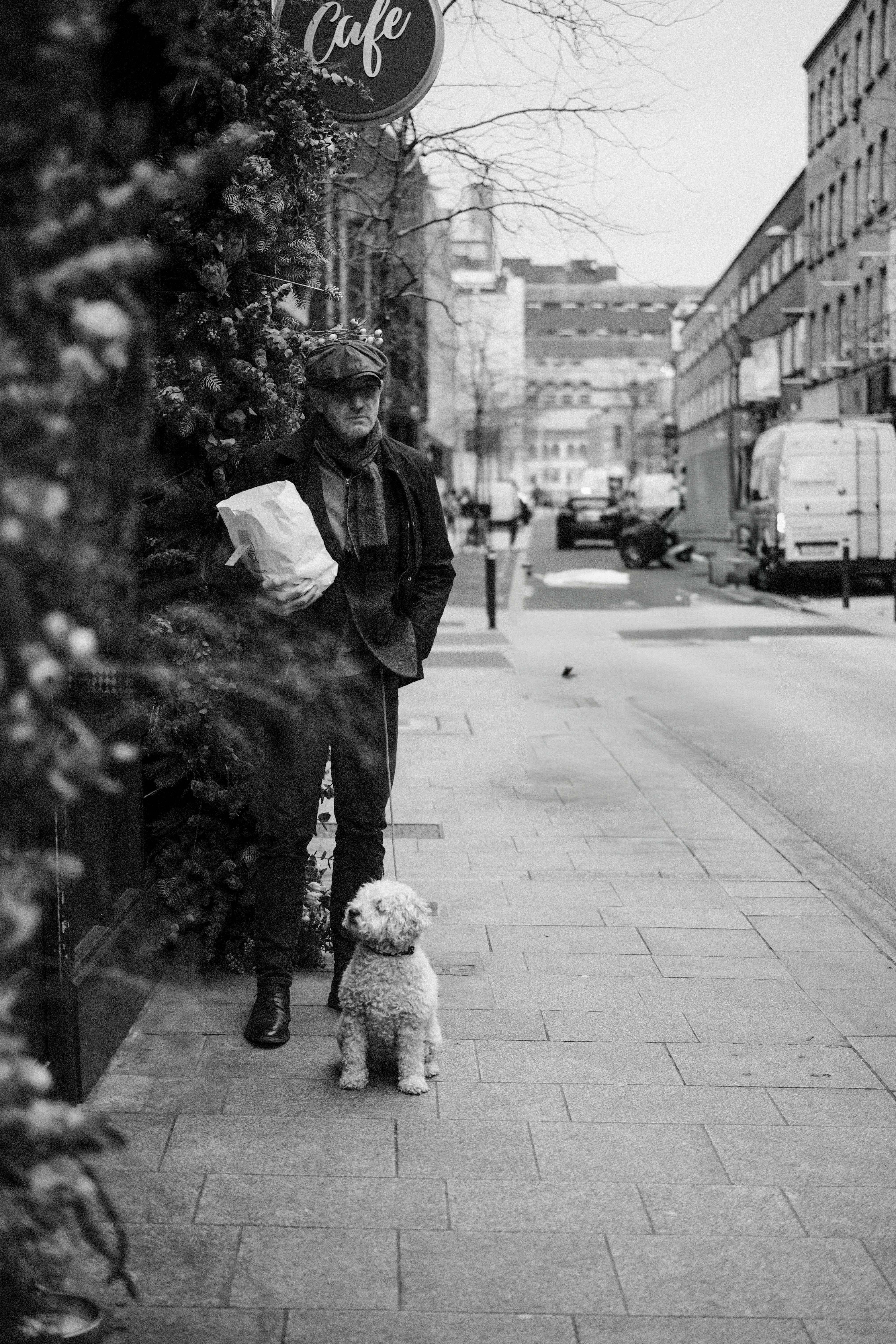 бесплатная Мужчина выгуливает собаку на городском тротуаре в Дублине, Ирландия. Стоковое фото