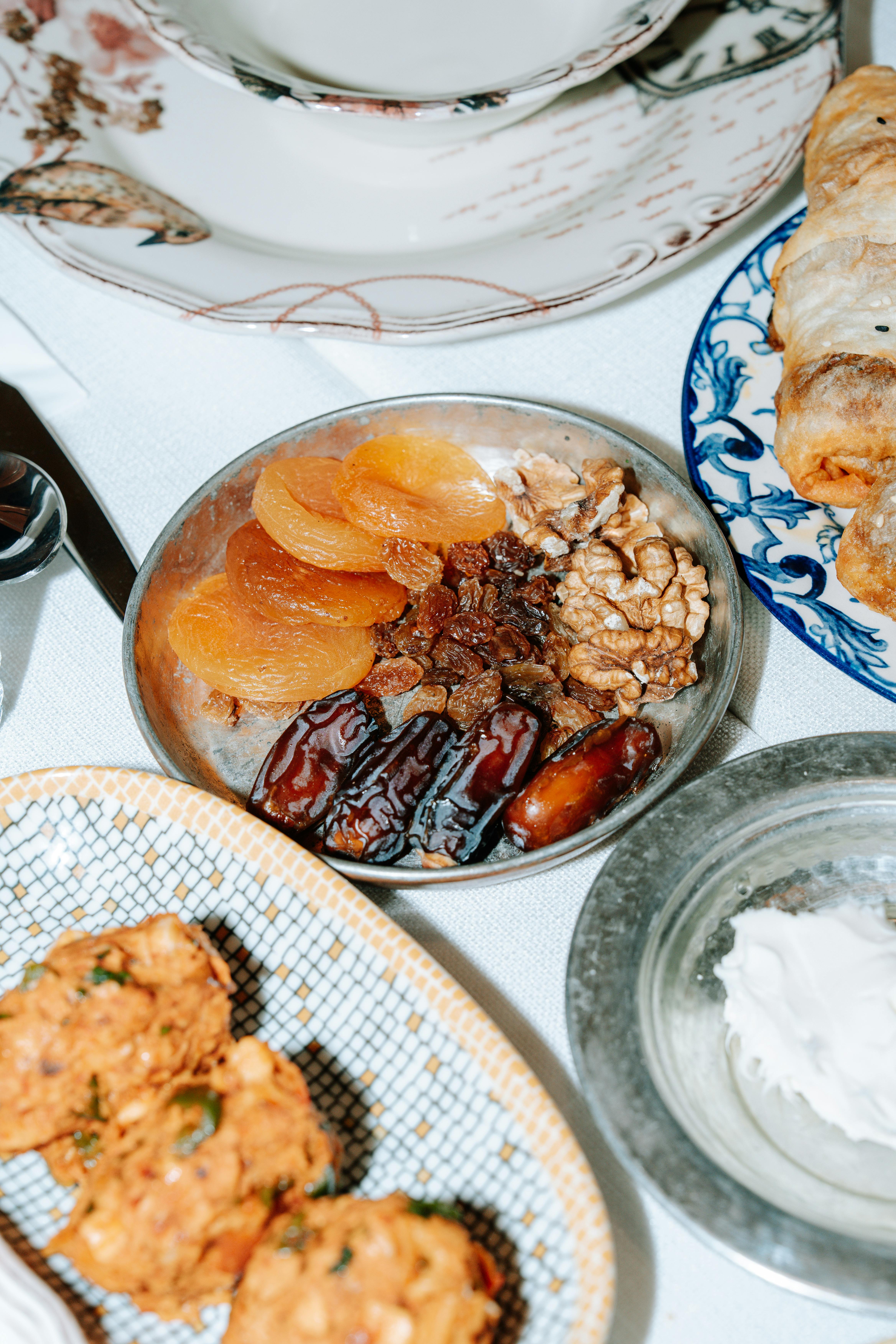 Gratuit Gros plan sur un plateau de fruits secs et de noix de qualité supérieure, dressé avec élégance sur une table à manger. Photos