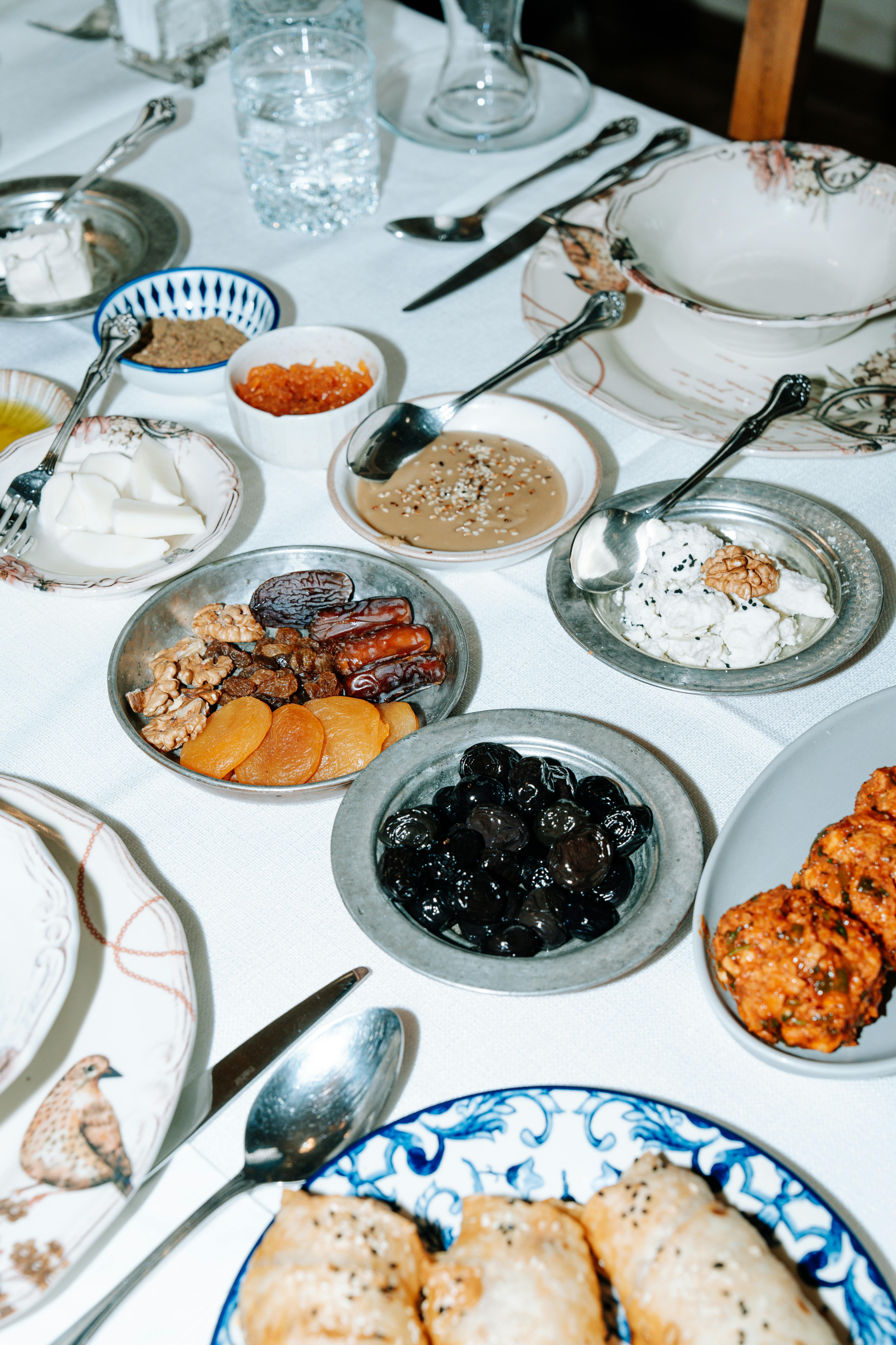 Gratis Et udvalg af assorterede retter og snacks dækket smukt på et middagsbord, klar til et festligt måltid. Lagerfoto