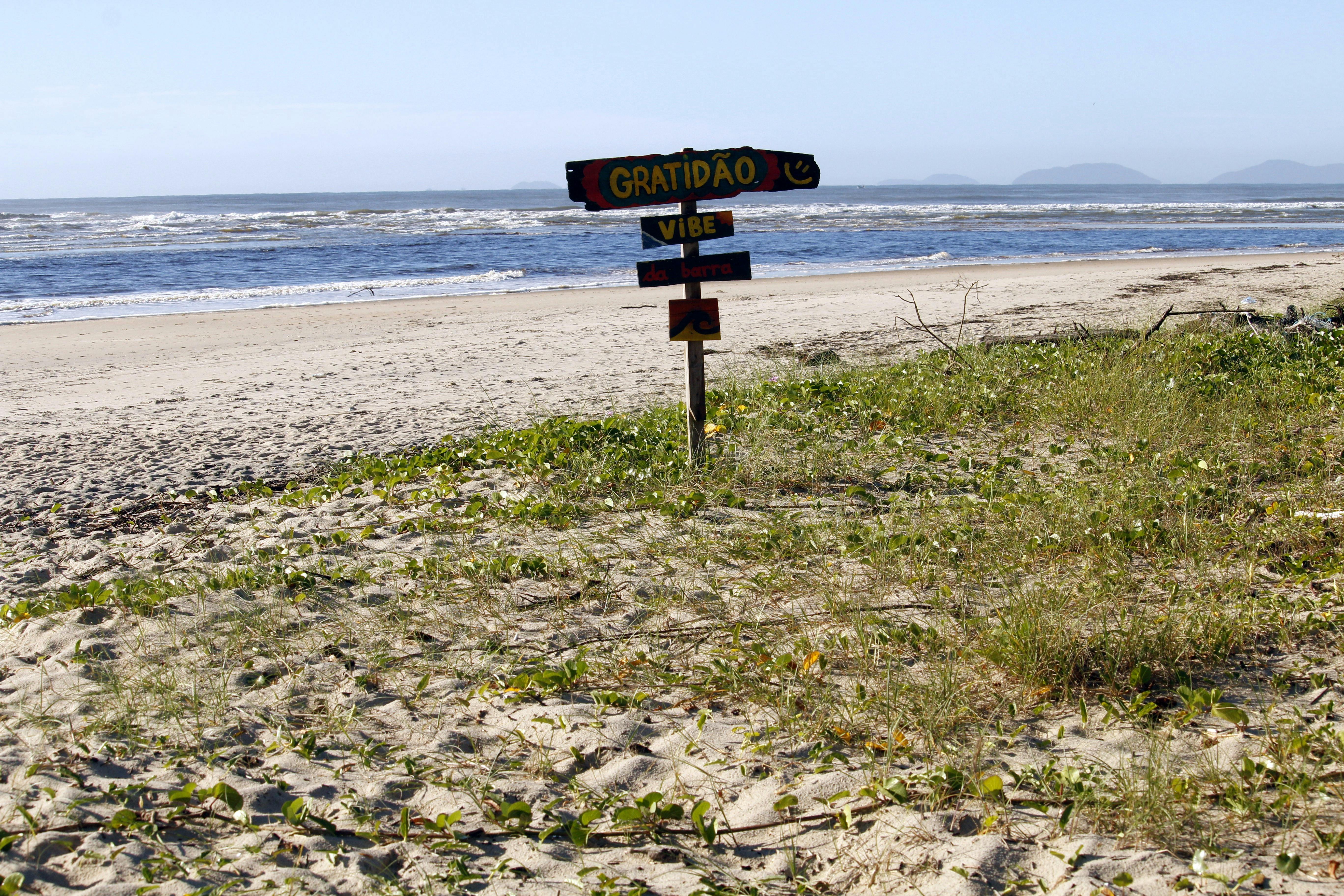 Gratuit Scenă de plajă liniștită cu semne de recunoștință și vibrații în Guaratuba, Brazilia, surprinzând o atmosferă senină de coastă. Fotografie de stoc
