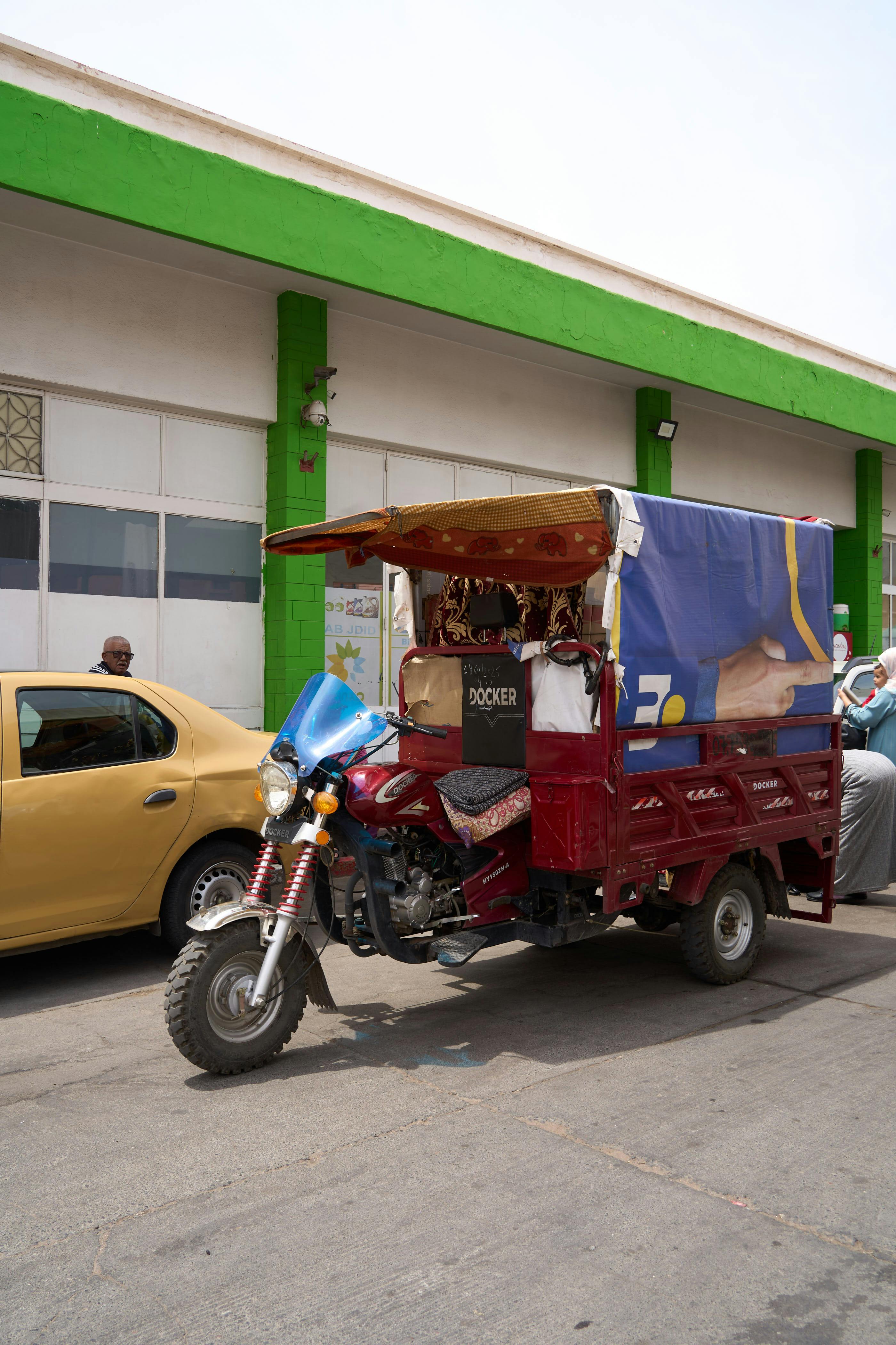 gratis Een kleurrijke tuk-tuk staat geparkeerd in een straat in Marrakech en laat de lokale cultuur en het vervoermiddel zien. Stockfoto