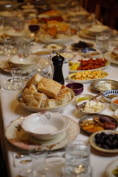 A festive dinner table set with a variety of traditional dishes and bread, perfect for a communal gathering.