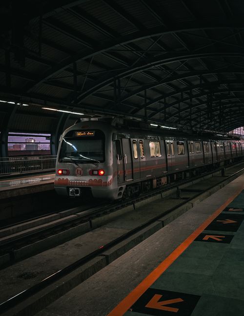 Free Sleek metro train awaiting departure at a vibrant urban station during twilight. Stock Photo