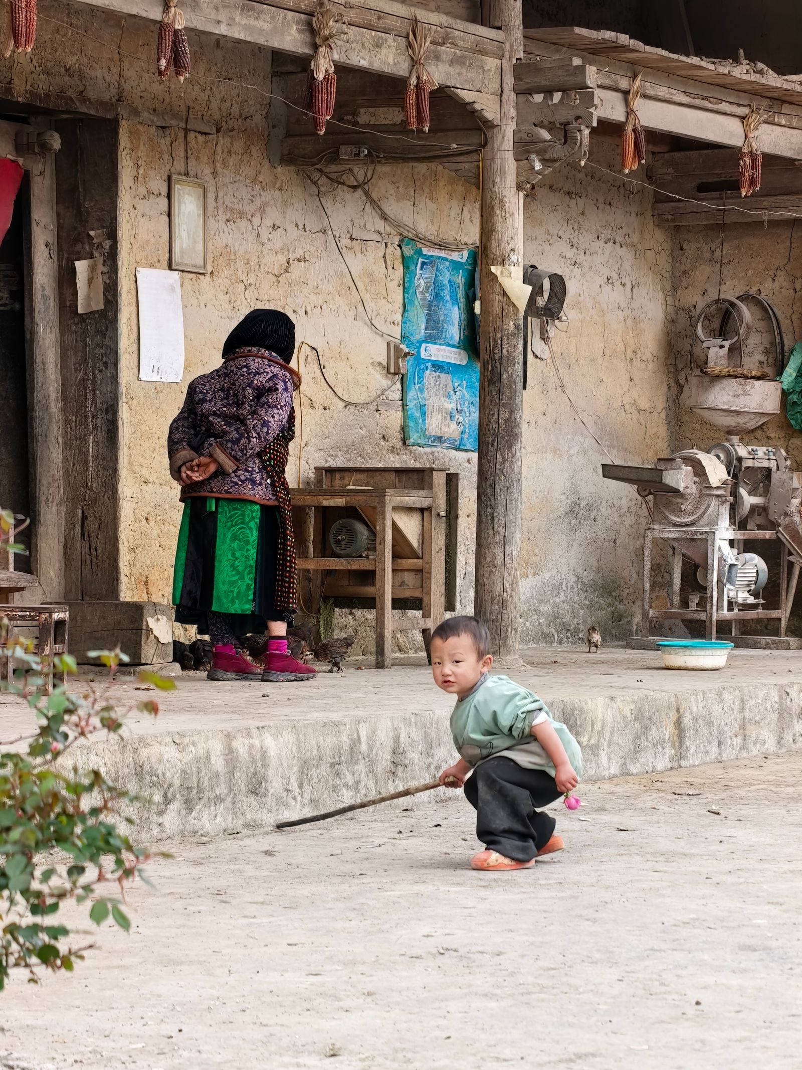 Rural family scene in a Vietnamese village with an older woman and child