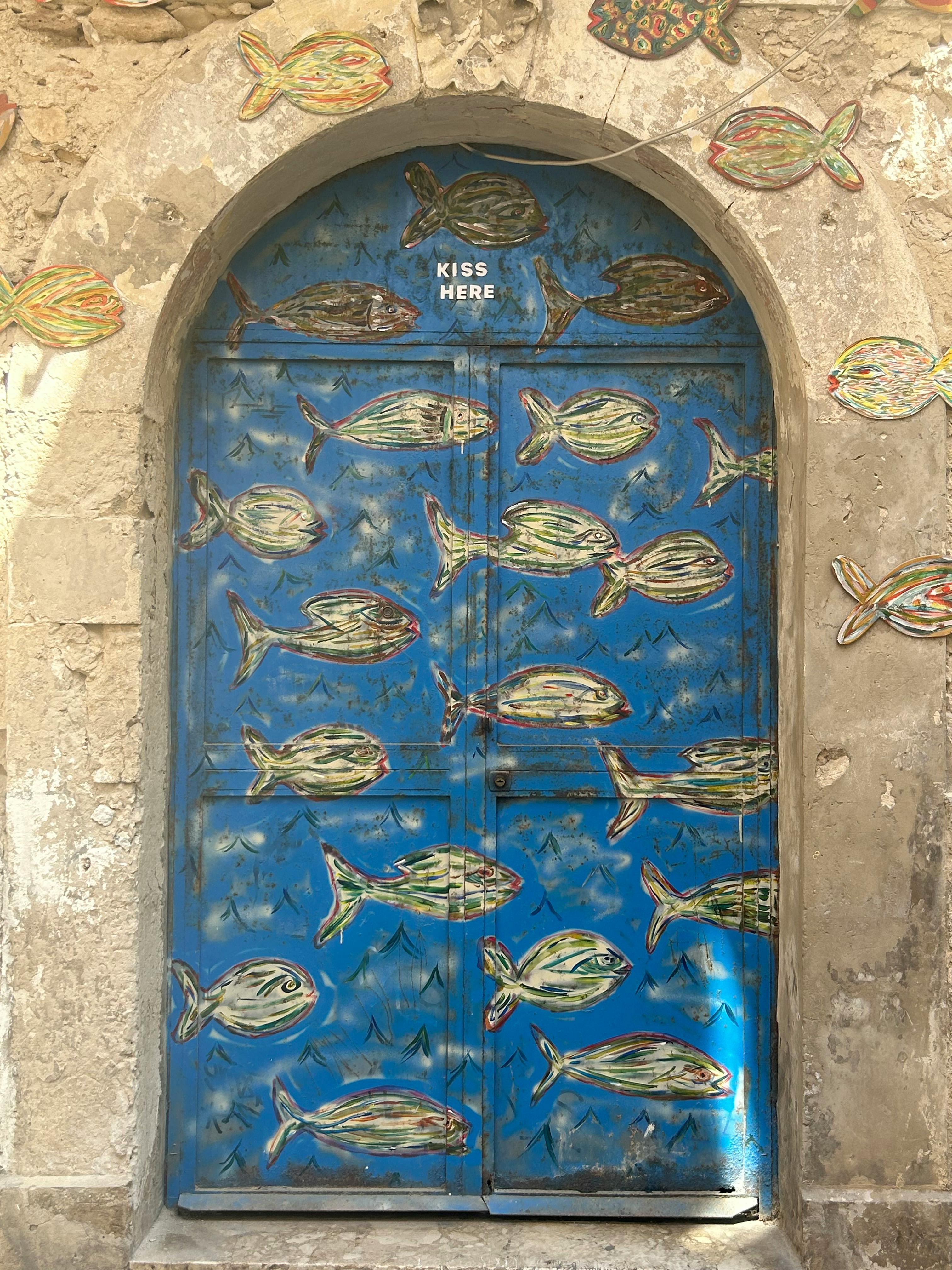 Gratis Nærbillede af en blå dør udsmykket med kunstneriske fiskedesigns på Sicilien, Italien. Lagerfoto