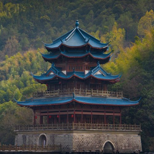 Free Photograph of a classic Chinese pagoda surrounded by vibrant forest highlighting traditional architecture. Stock Photo