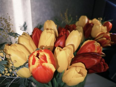A colorful tulip bouquet featuring red and yellow flowers in an indoor arrangement.