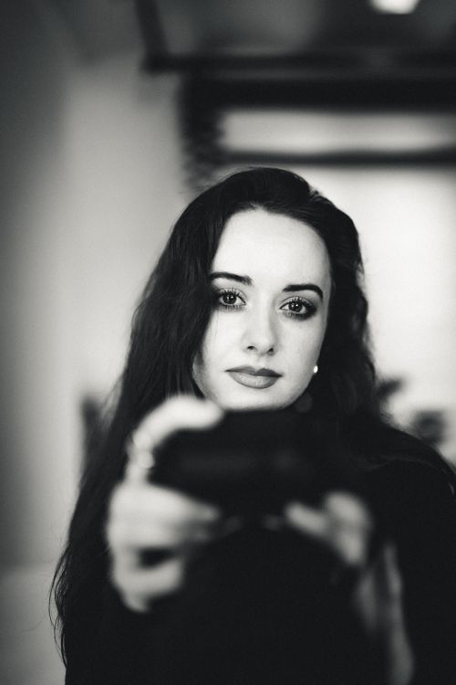 Free Portrait of a woman gazing at the camera in a moody, black and white setting. Stock Photo