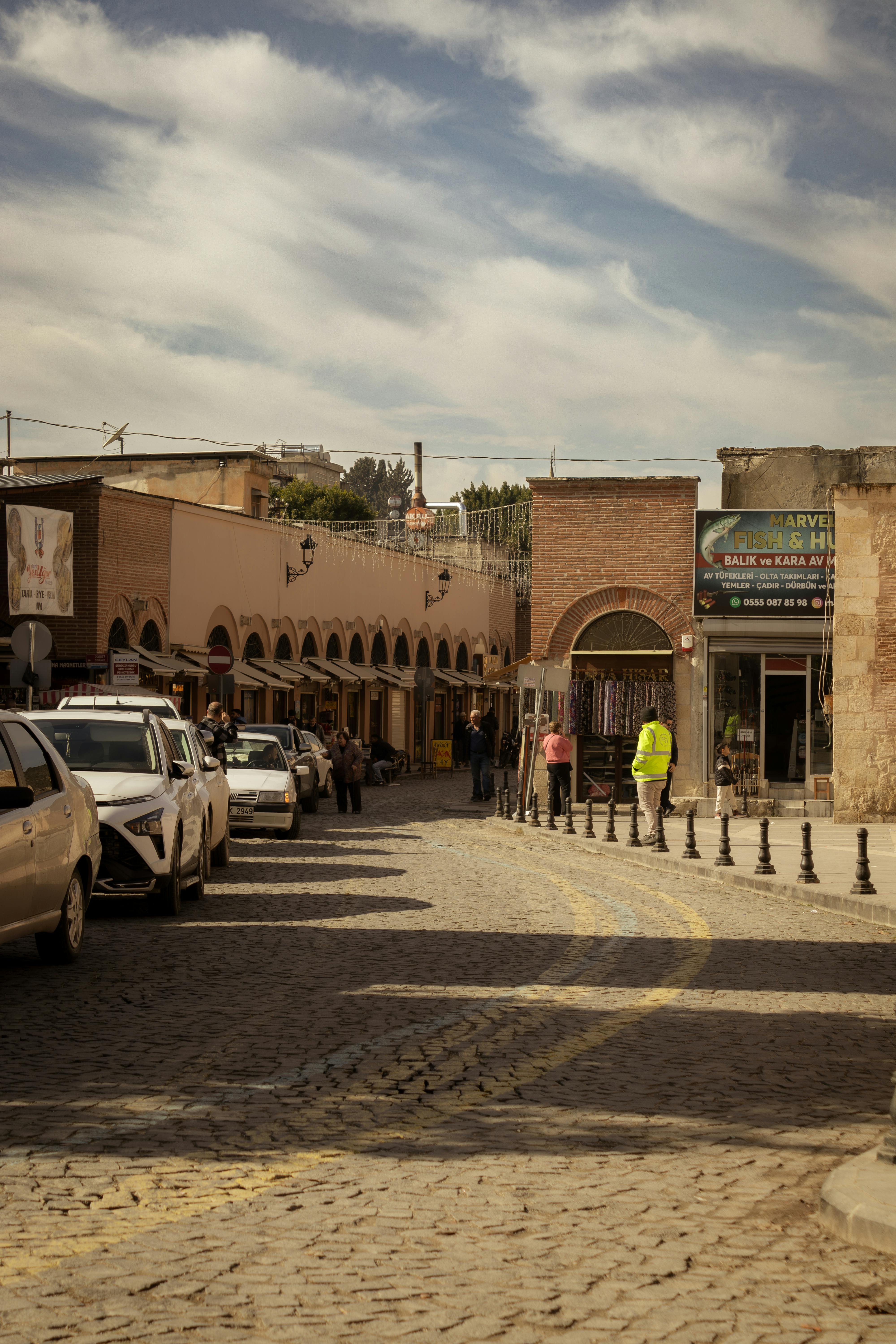 免费 阳光明媚的街景，展现了中东的集市，汽车和行人熙熙攘攘，生动地描绘了日常生活。 素材图片