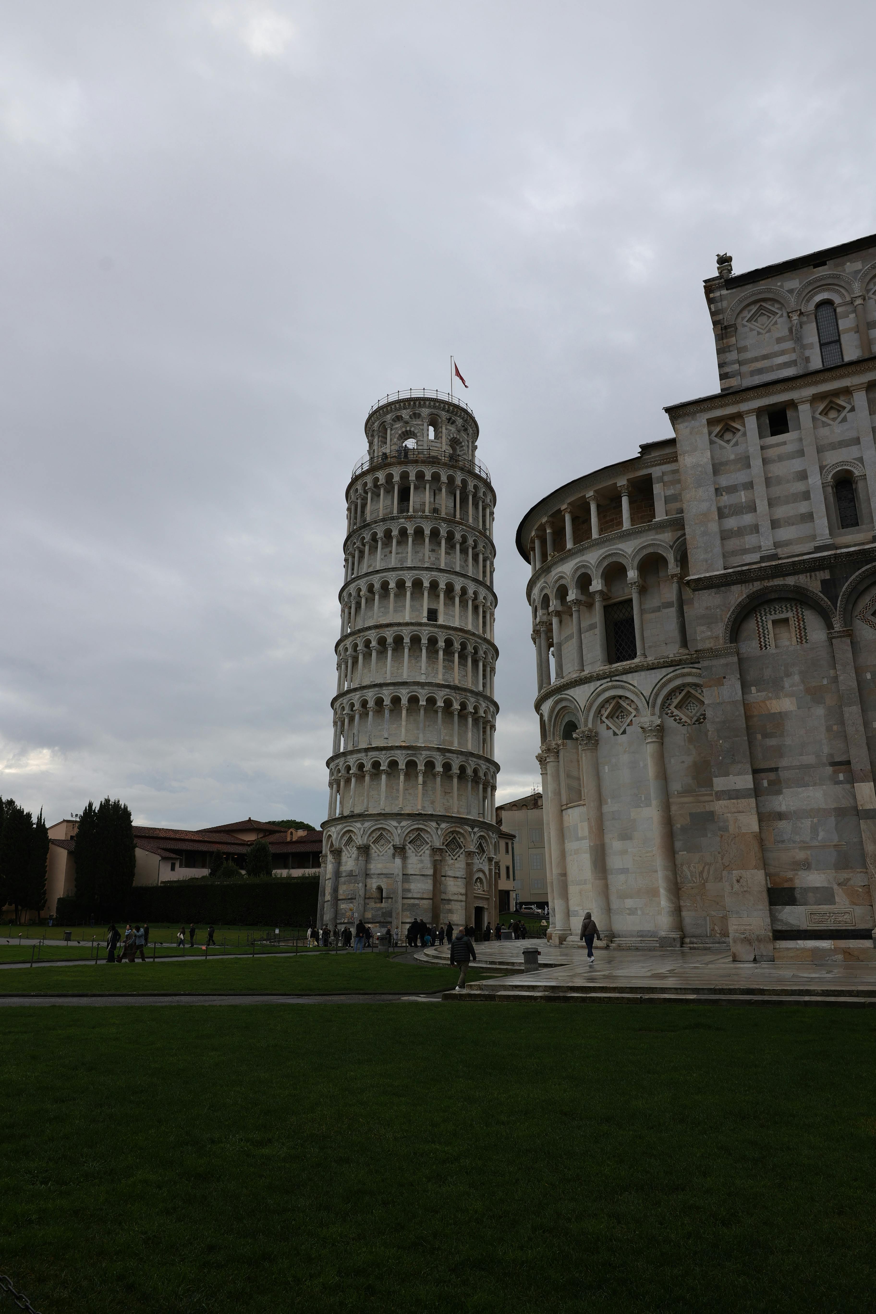 免费 在阴天中拍摄的著名比萨斜塔及其毗邻的大教堂。 素材图片