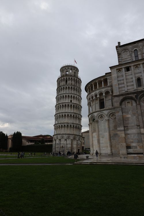 Free Capture of the renowned Leaning Tower of Pisa with adjoining Cathedral, under a cloudy sky. Stock Photo