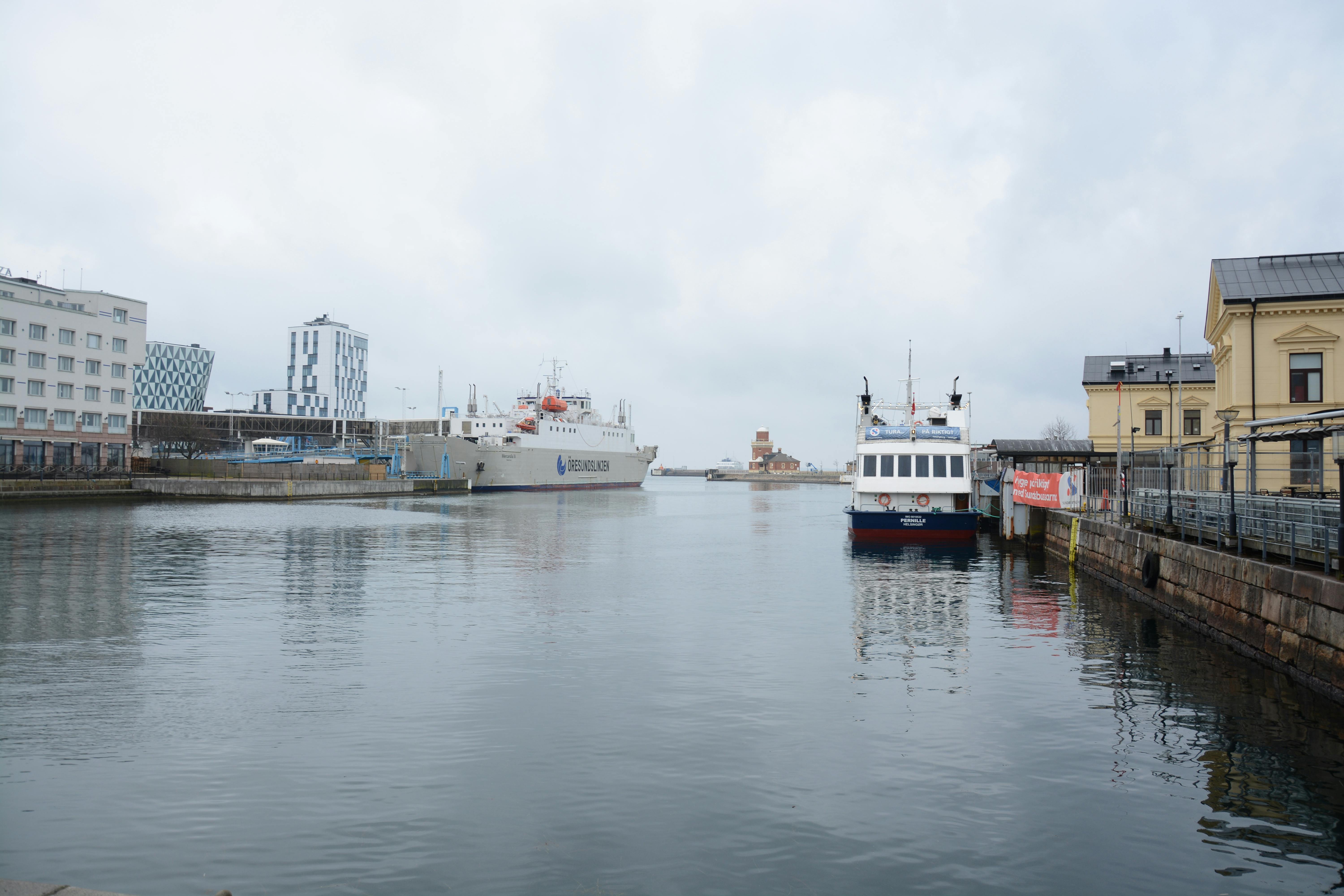 grátis Cena pitoresca de um porto com arquitetura moderna e barcos atracados em um dia nublado. Foto profissional