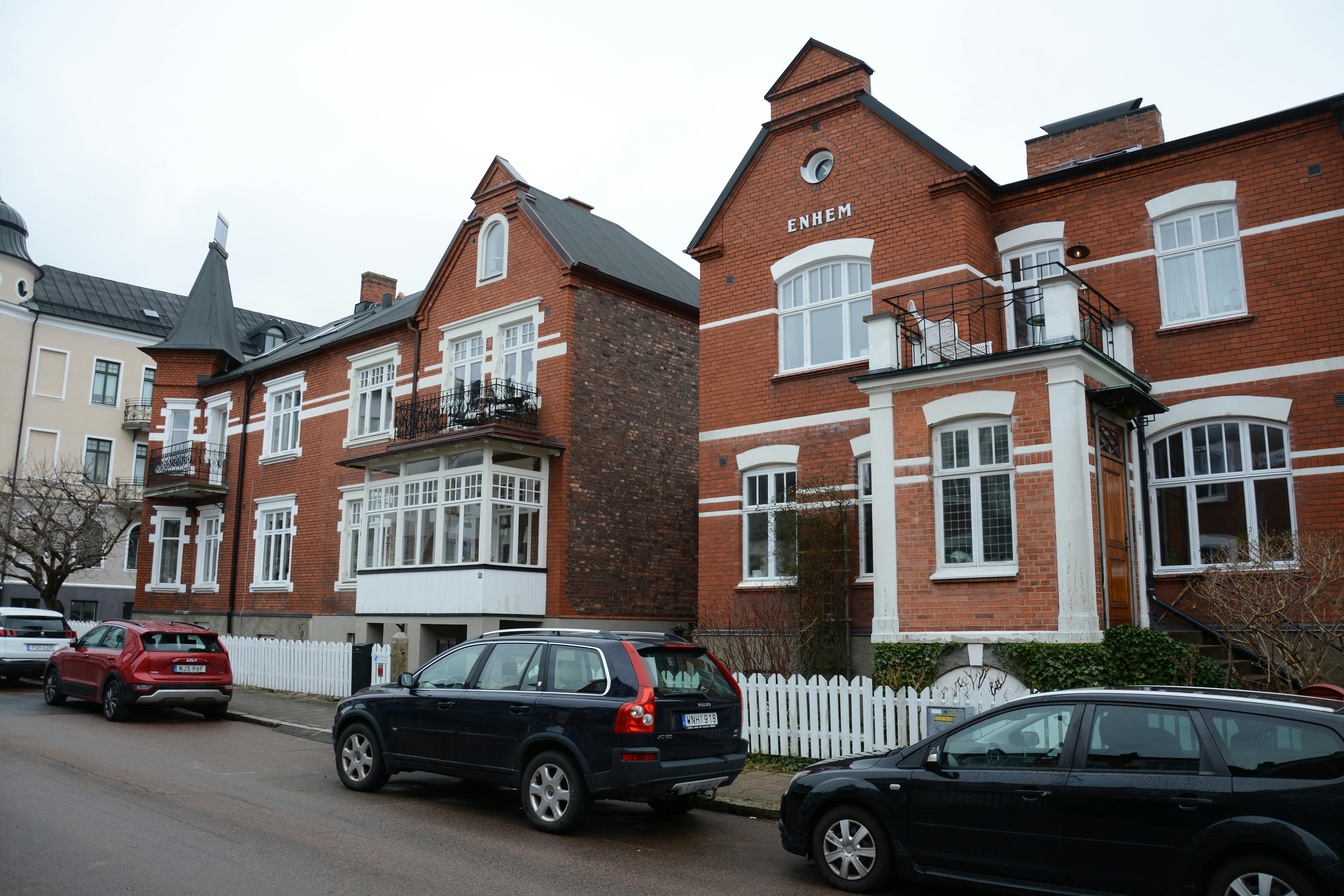 Gratis Europæisk gadebillede med klassiske røde murstenshuse og parkerede biler, der fremviser charmerende arkitektur. Lagerfoto