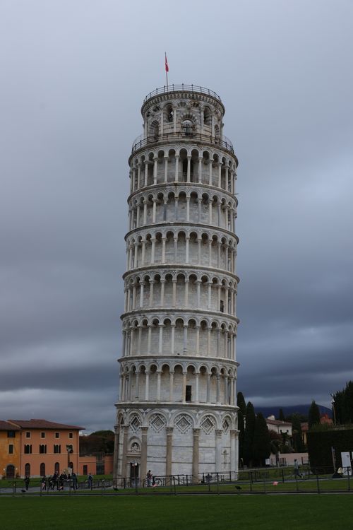 Free Iconic Leaning Tower of Pisa standing tall against a dramatic cloudy sky in Italy. Stock Photo