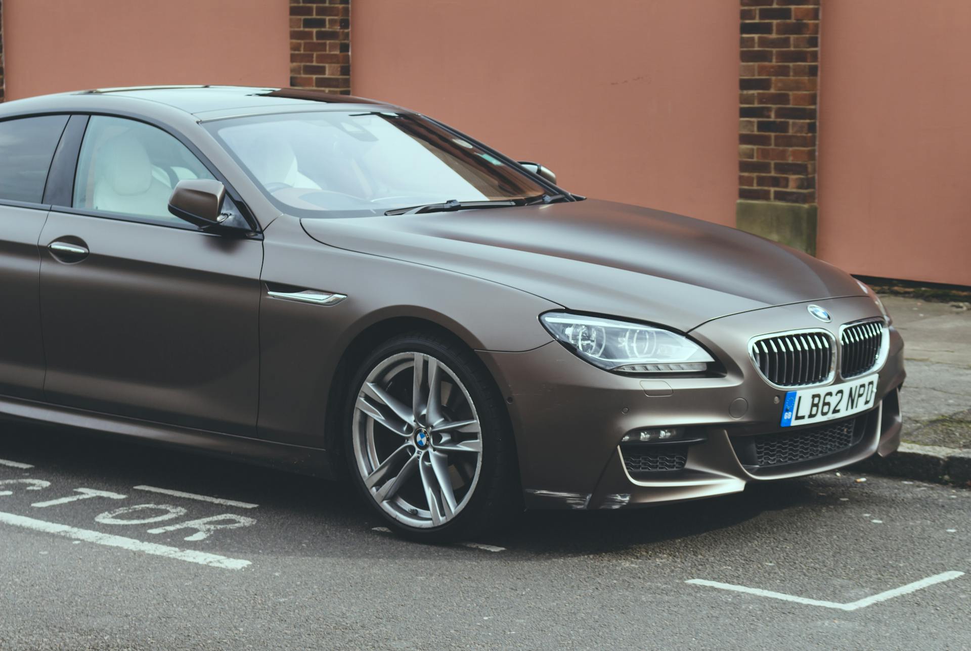 Luxury BMW 6 Series coupe parked on an urban street, showcasing sleek design and elegance.