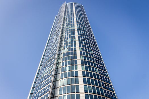 从低角度仰望现代摩天大楼，玻璃窗映衬着清澈的蓝天