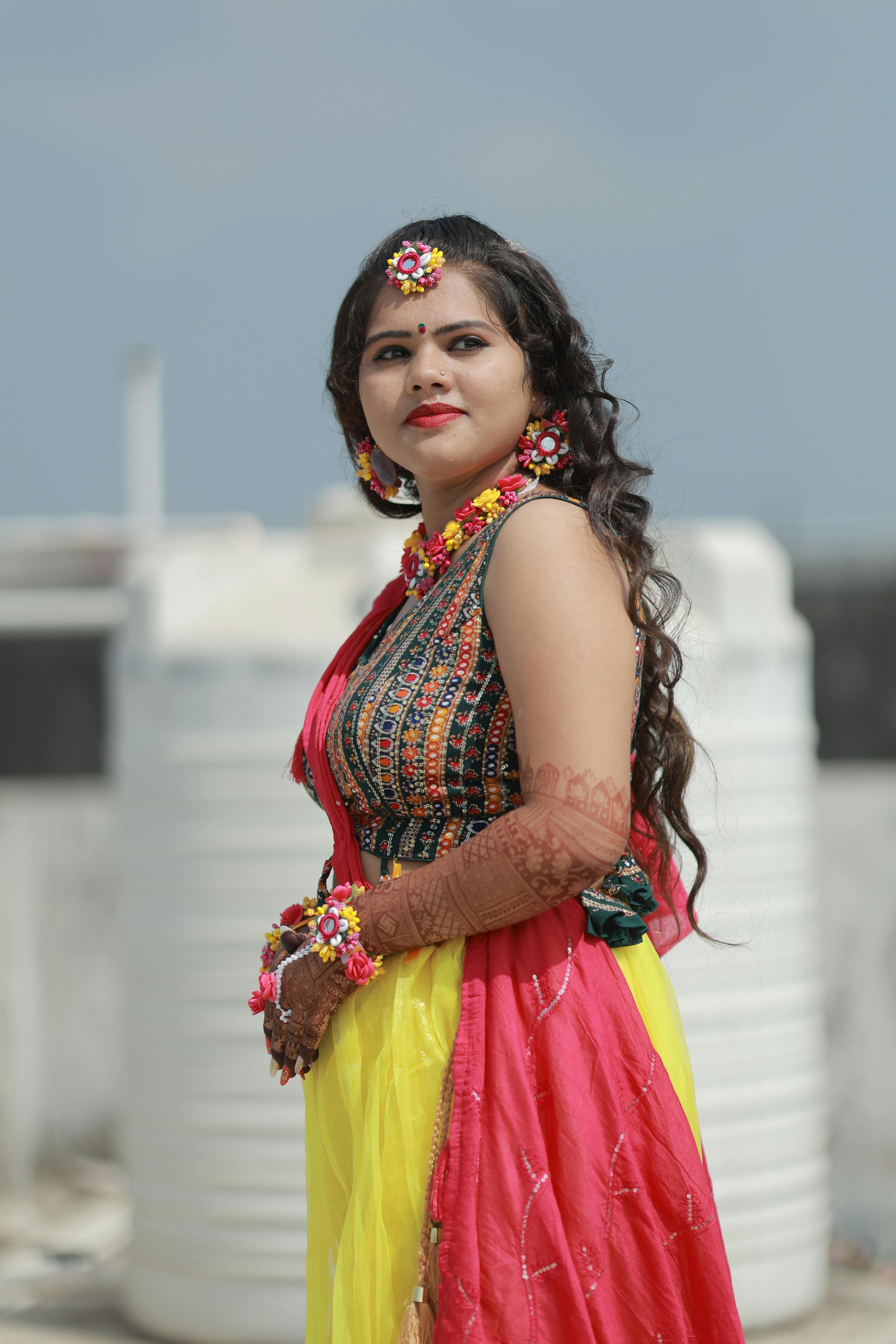 Gratis Et levende udendørsportræt af en traditionel brud i farverigt tøj og blomstertilbehør. Lagerfoto