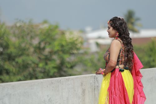 Free A vibrant portrait of an Indian bride in traditional attire with henna, posing outdoors. Stock Photo