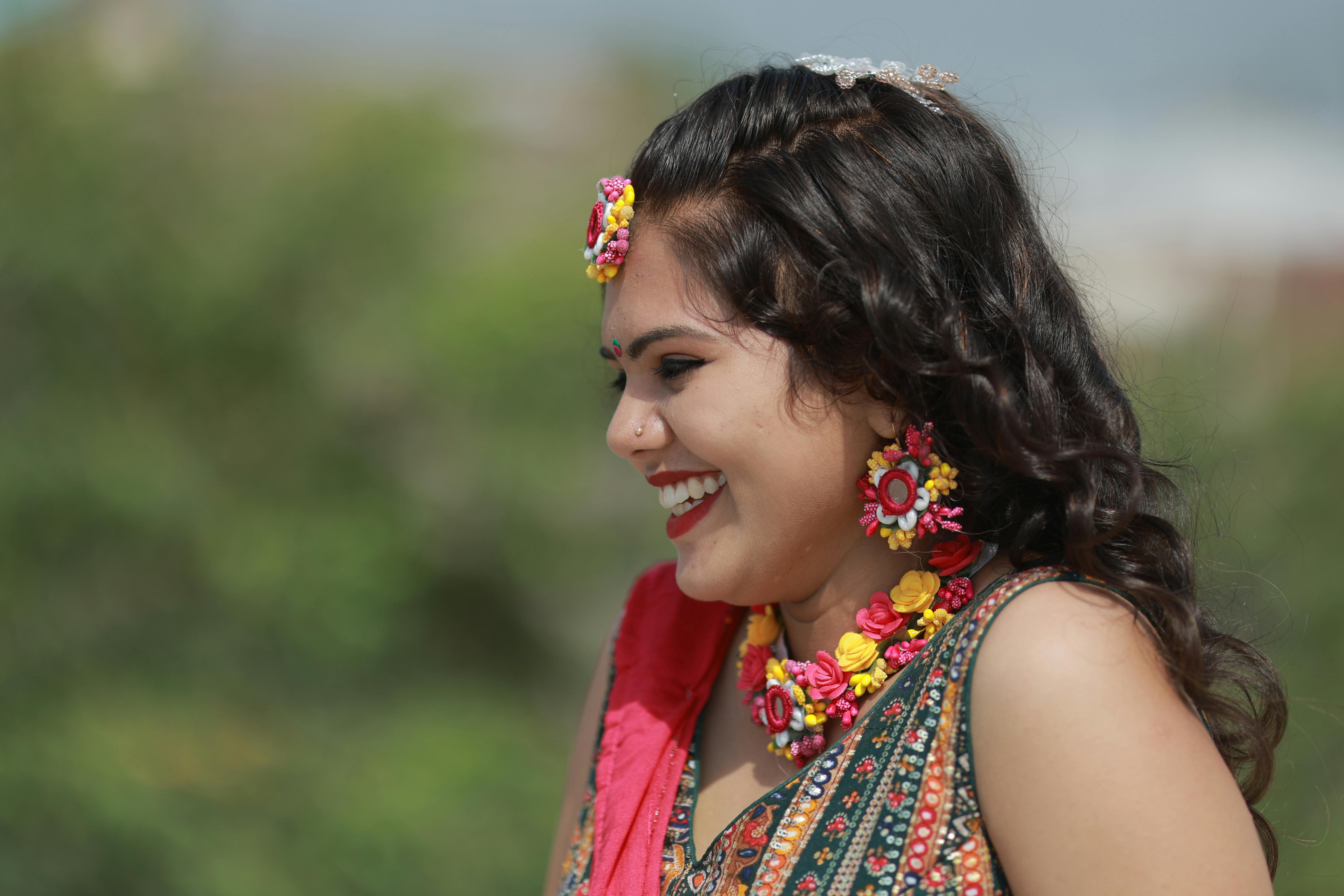 gratis Een prachtige bruid, getooid met bloemenjuwelen, lacht vrolijk in een buitenomgeving. Stockfoto