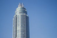 一座现代摩天大楼的玻璃立面映衬着清澈的蓝天，展现了城市建筑的魅力