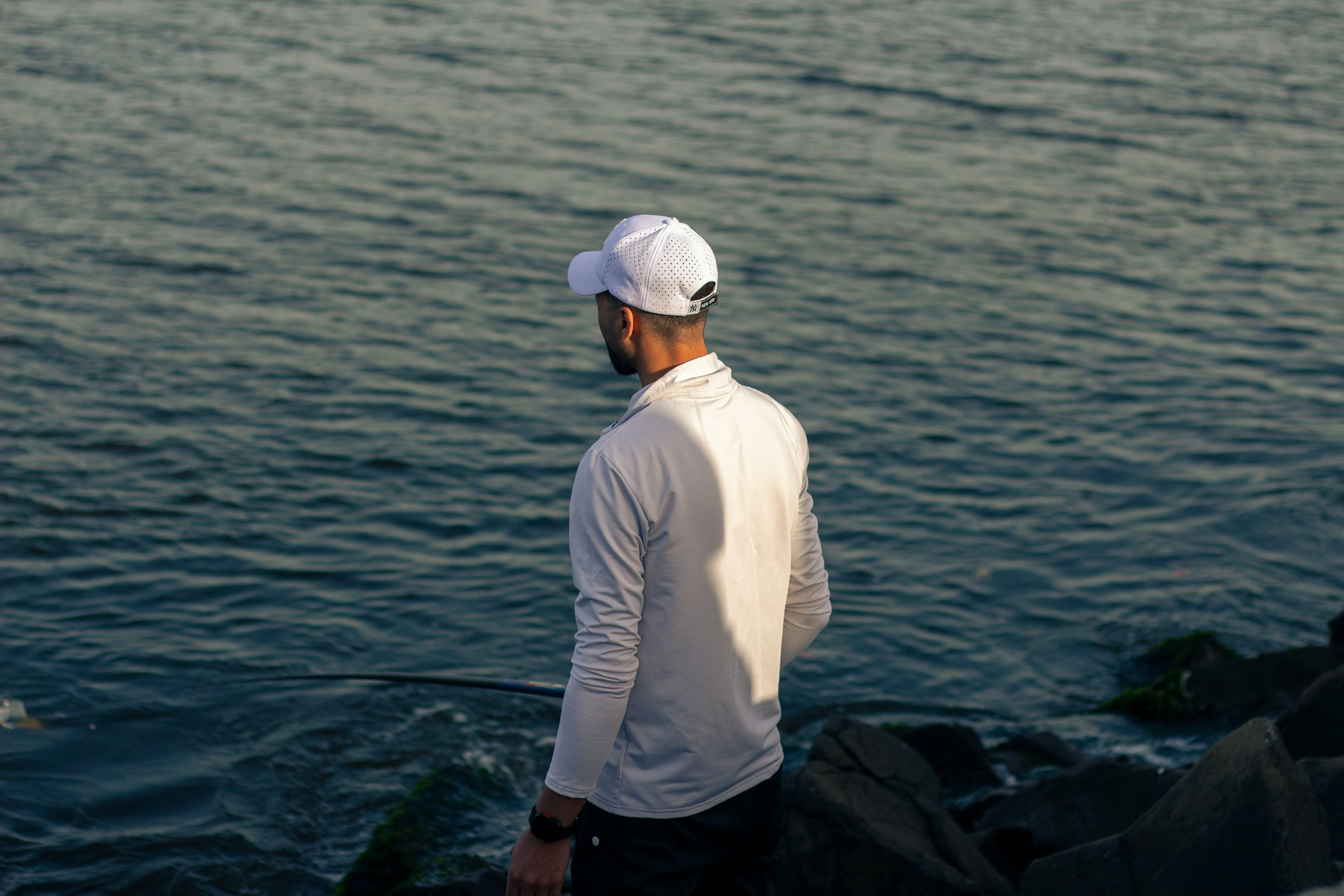 Zadarmo Pokojná scéna muža loviaceho ryby na skalnatom pobreží v Ras El-Bar v Egypte. Fotka z fotobanky