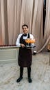 Smiling Waiter Serving Colorful Cocktails at Event