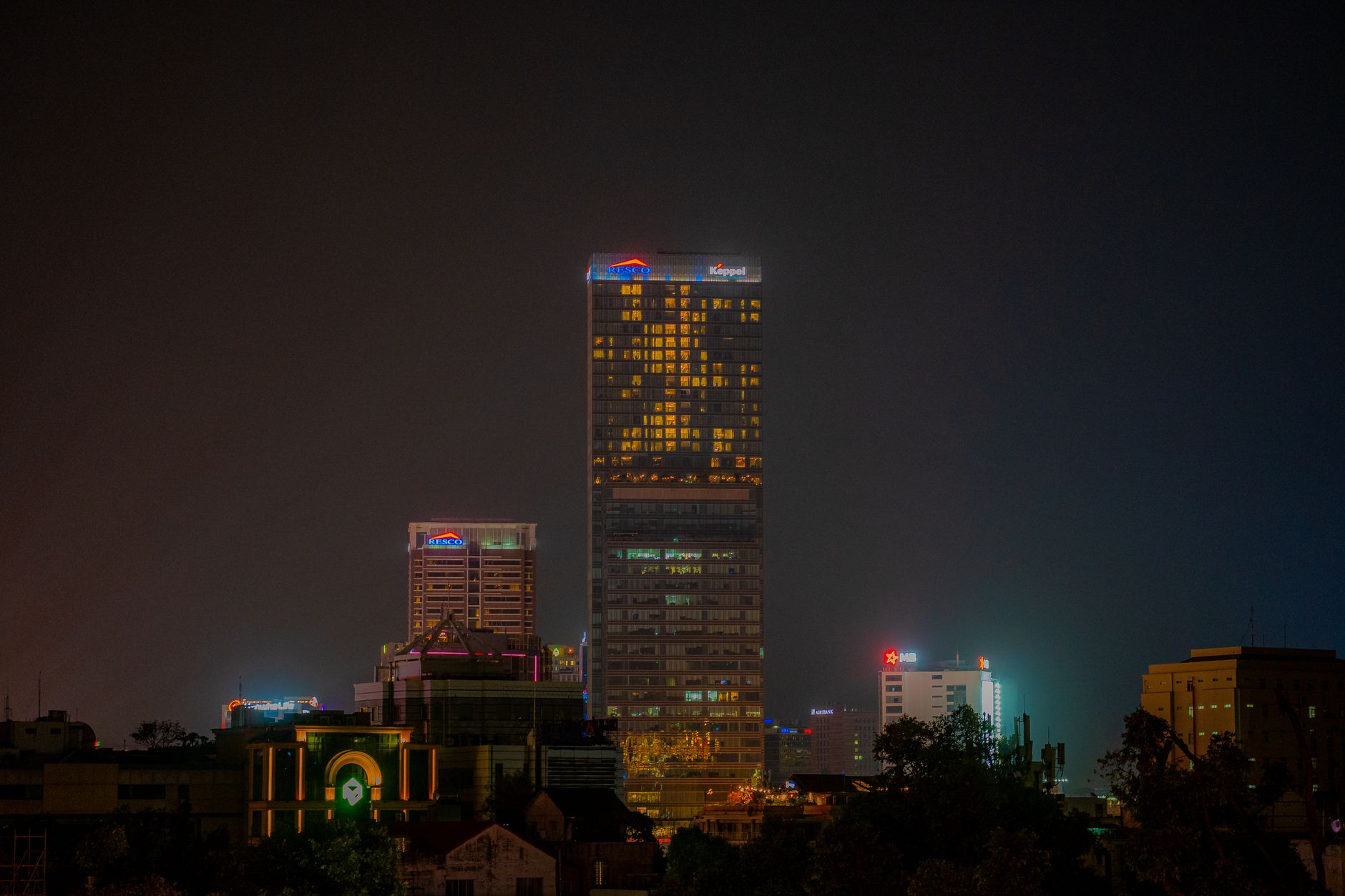 Illuminated skyscrapers in the night skyline of Ho Chi Minh City, showcasing urban architecture.