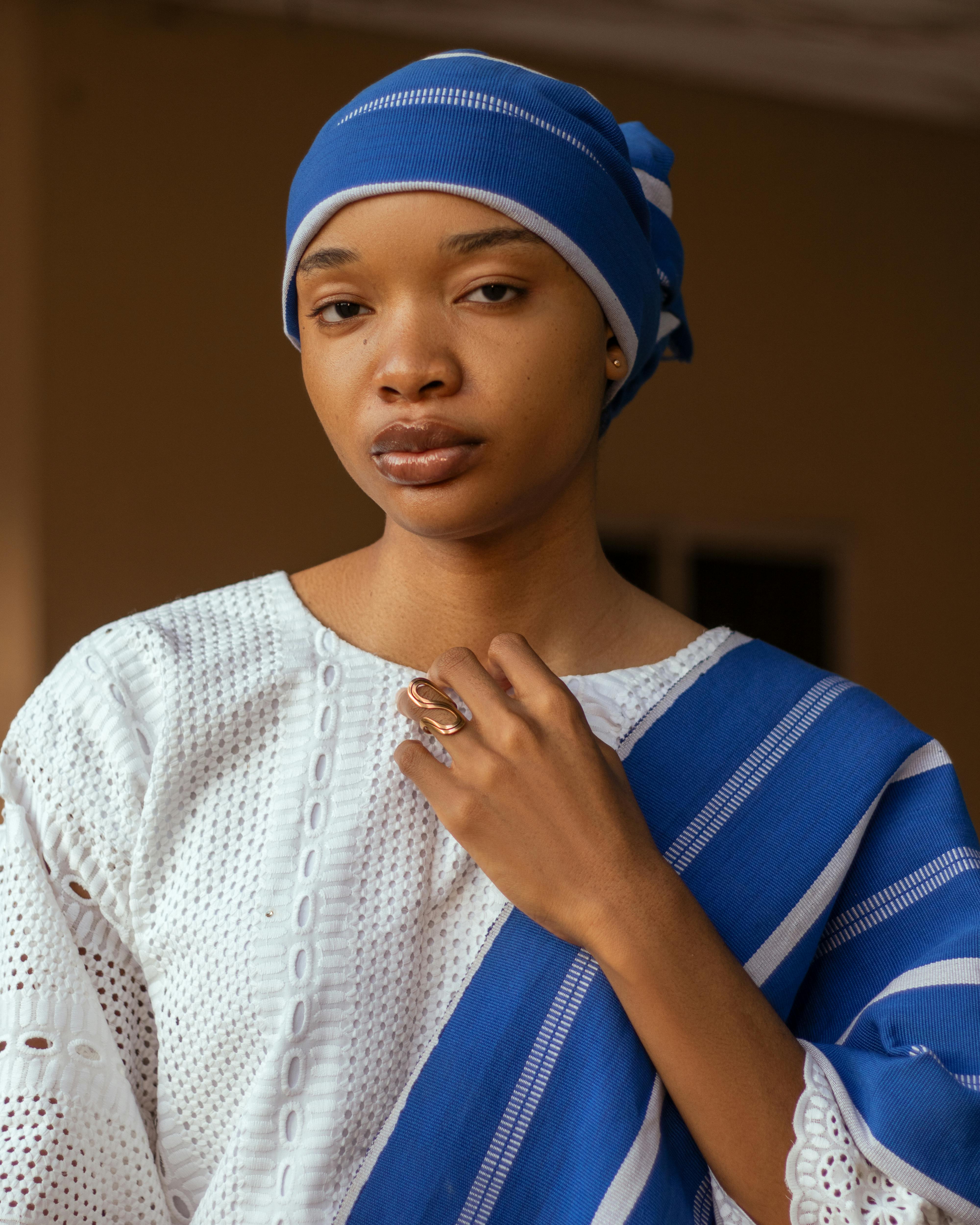 grátis Retrato elegante de uma mulher vestida com roupas tradicionais azuis e brancas, com expressão serena. Foto profissional