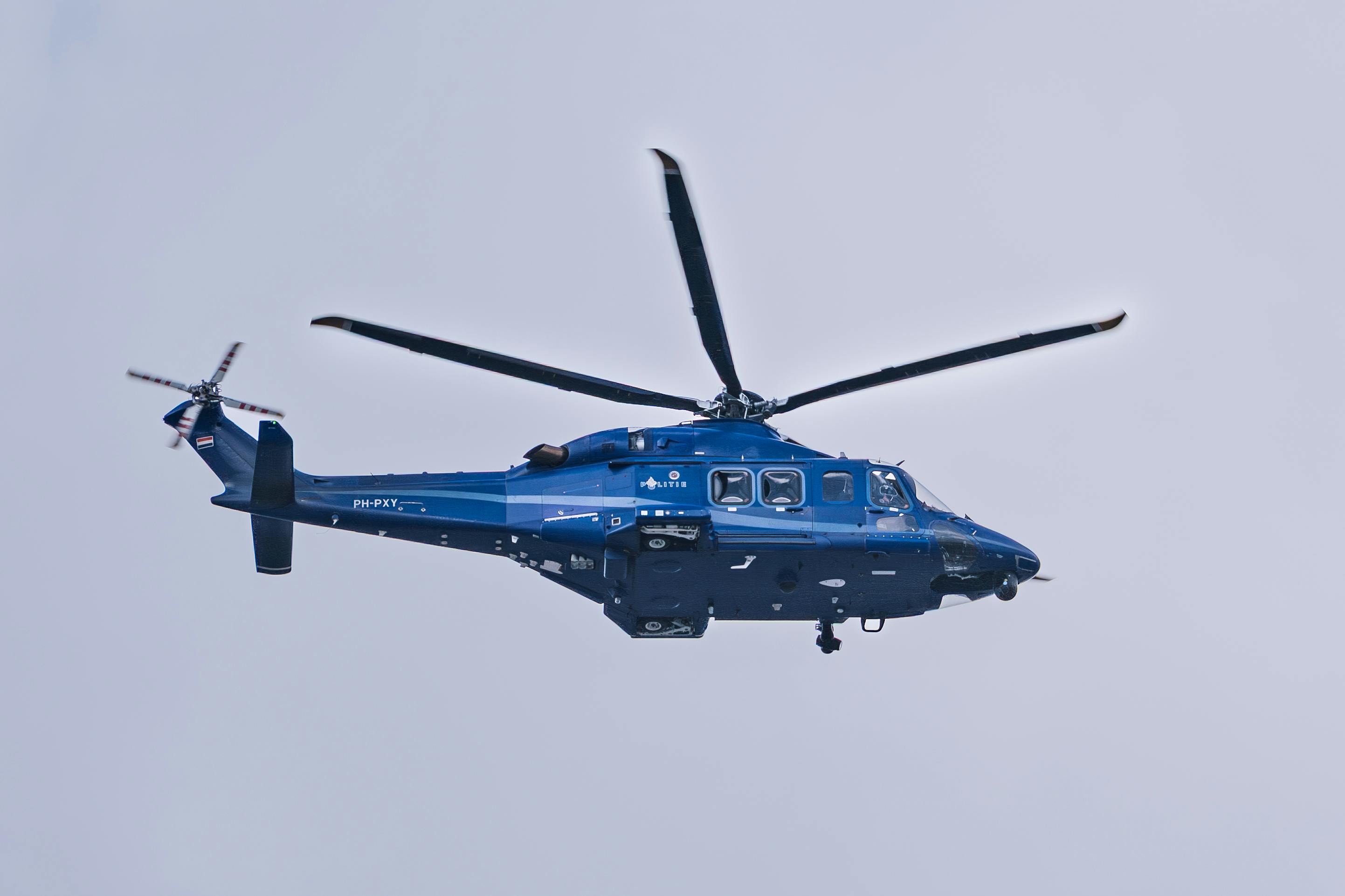 Miễn phí Một chiếc trực thăng màu xanh bay cao trên nền trời trong xanh, thể hiện công nghệ hàng không tiên tiến. Ảnh lưu trữ