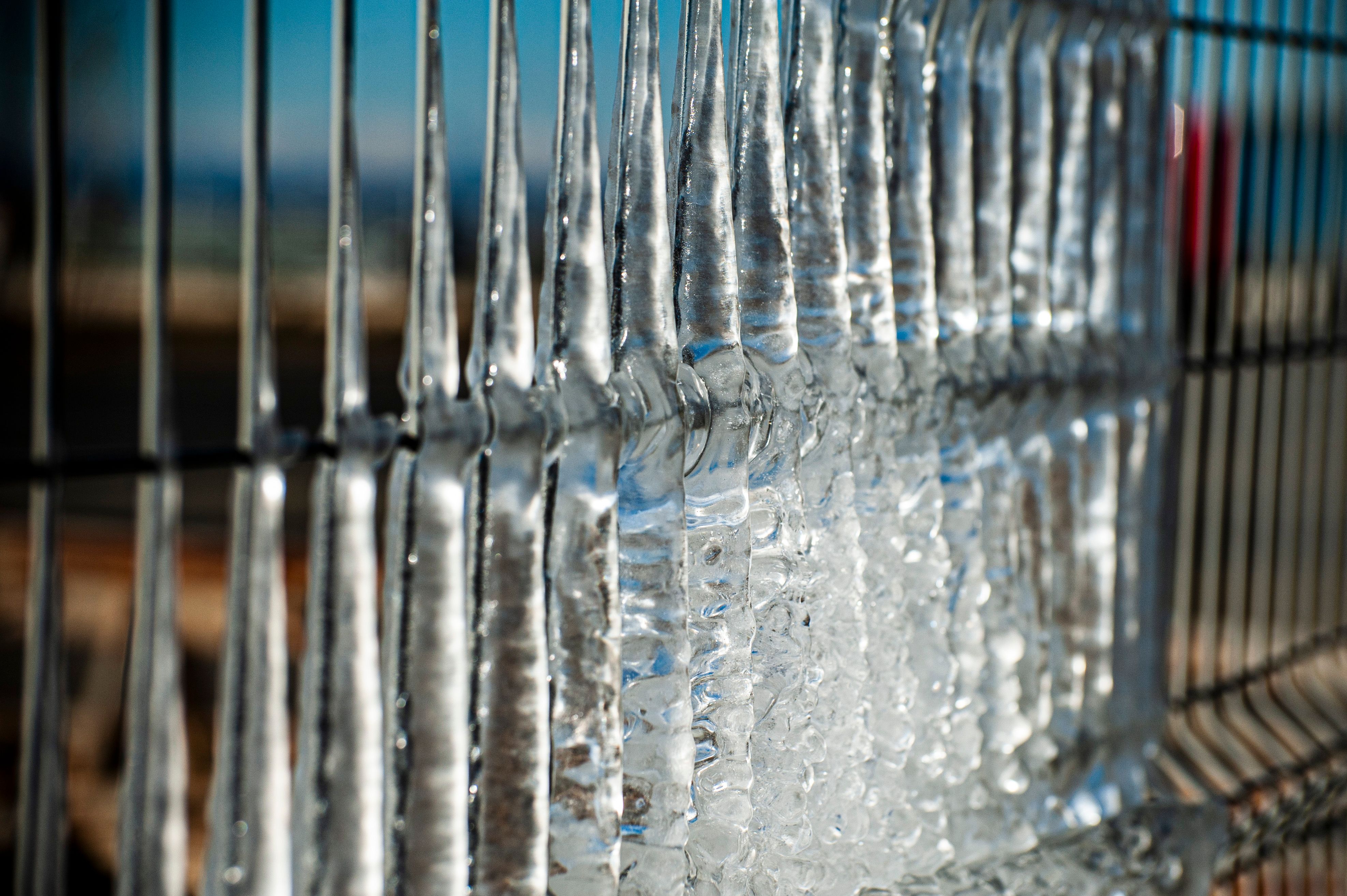 Close-up of icicles forming on a metal fence in Tbilisi, Georgia, winter scene.