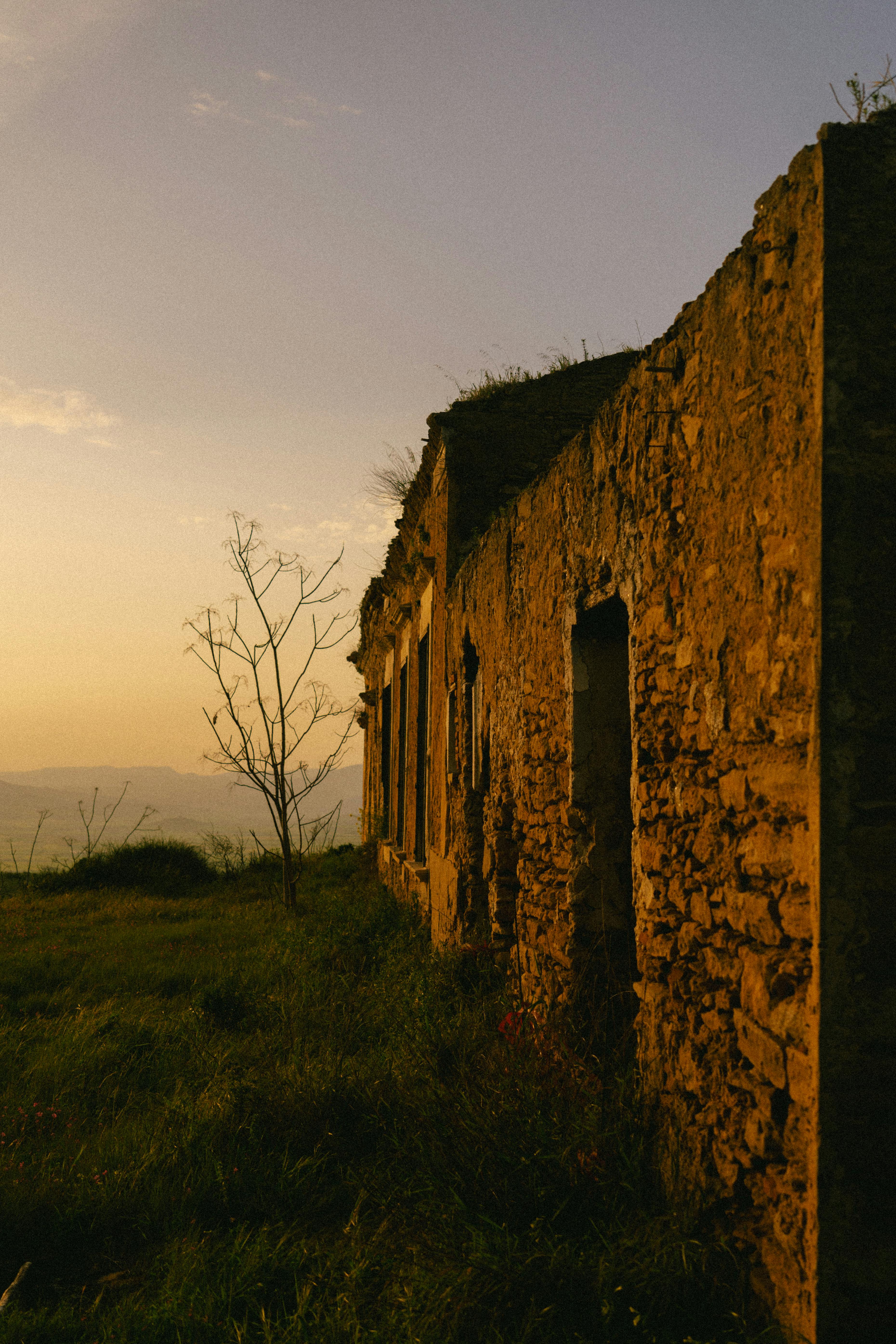 무료 시칠리아 니세미에 있는 소박한 돌 건물은 따뜻한 석양의 분위기와 전원적인 매력을 고스란히 담아내고 있습니다. 스톡 사진
