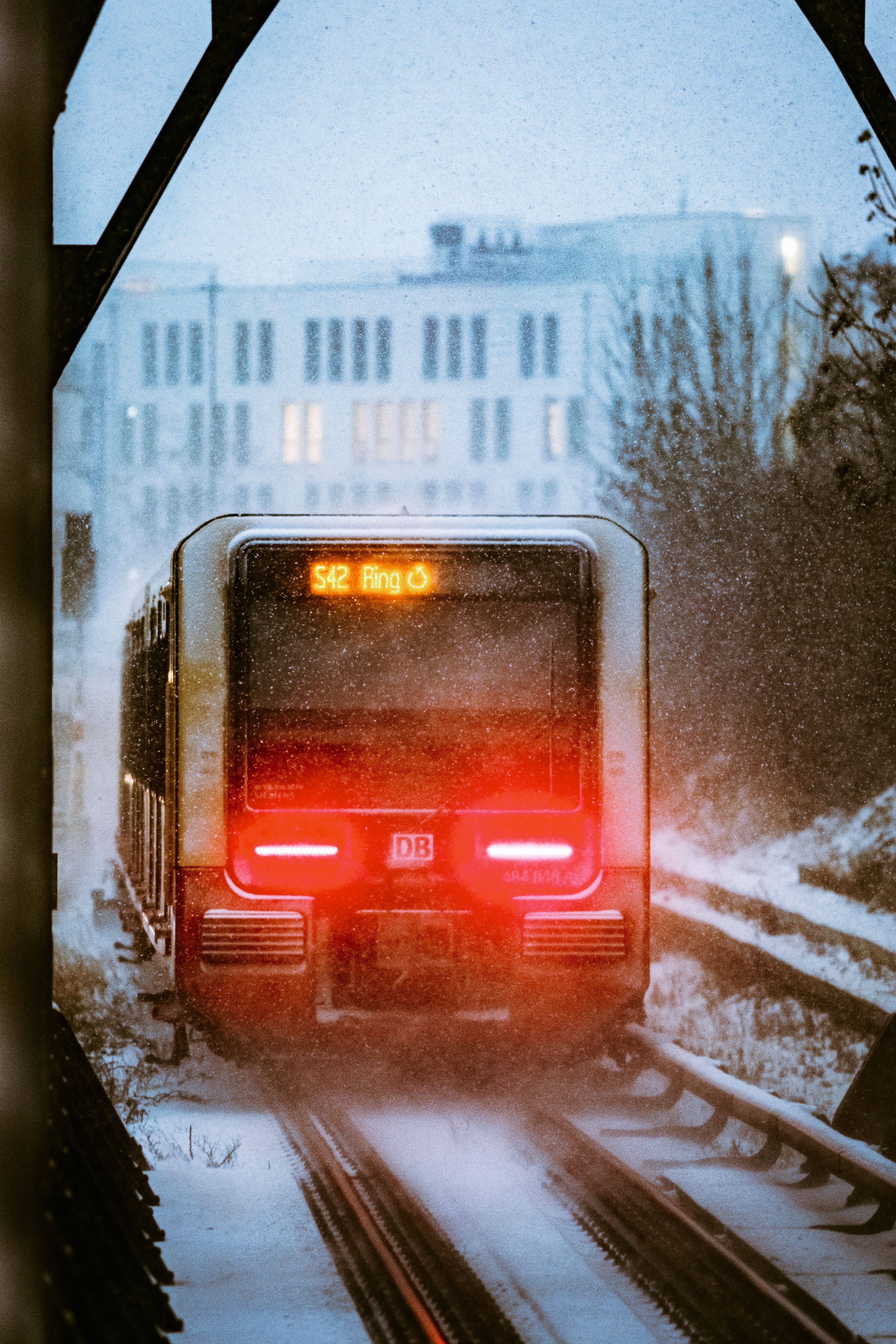 A Berlin S-Bahn train on snowy tracks during winter, showcasing urban transit.
