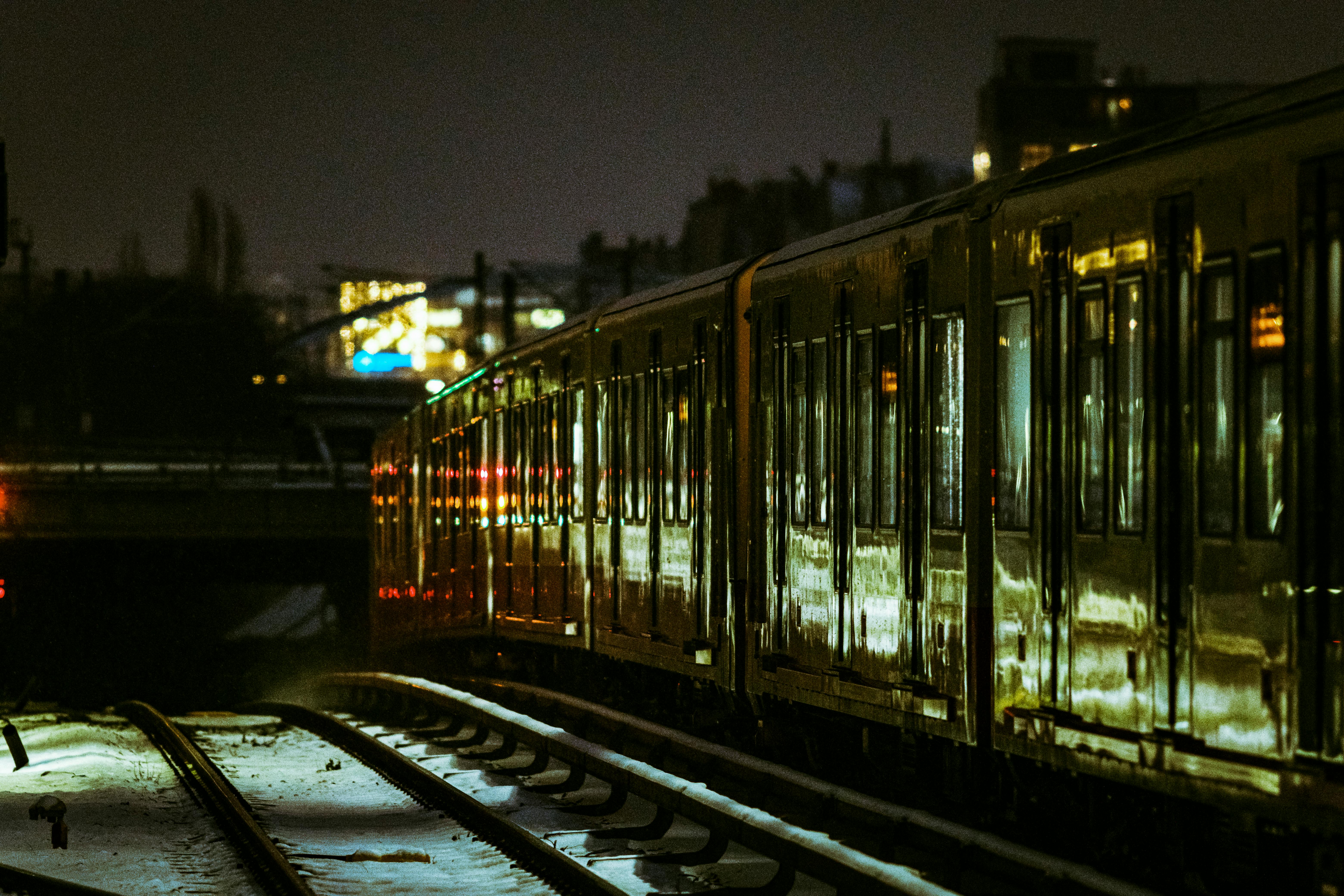 Gratuit Un tren circulă noaptea pe șinele din Berlin, reflectând luminile orașului. Fotografie de stoc