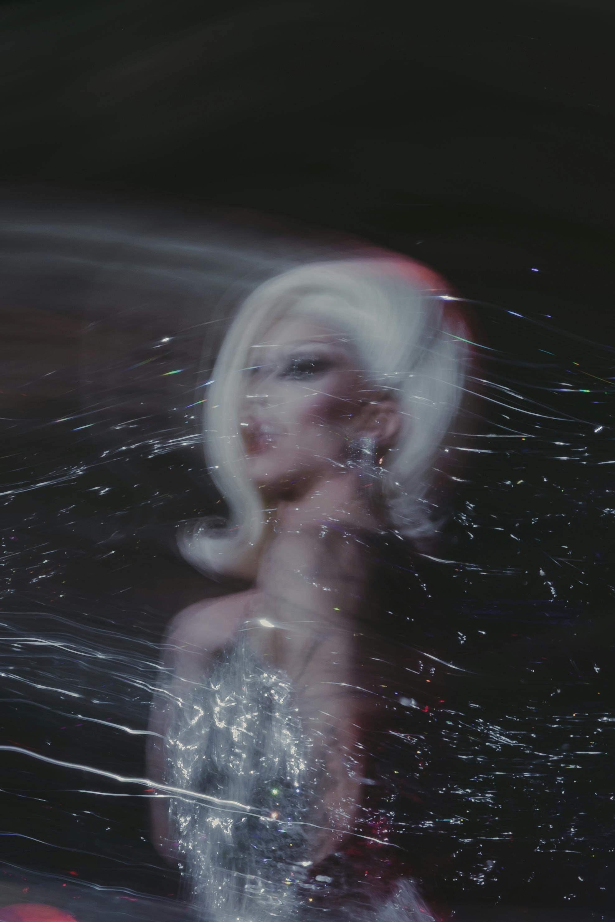 Безкоштовне Абстрактне розмиття руху гламурної дрэг-виконавця у блискучому вбранні, зняте в художньому стилі. стокове фото