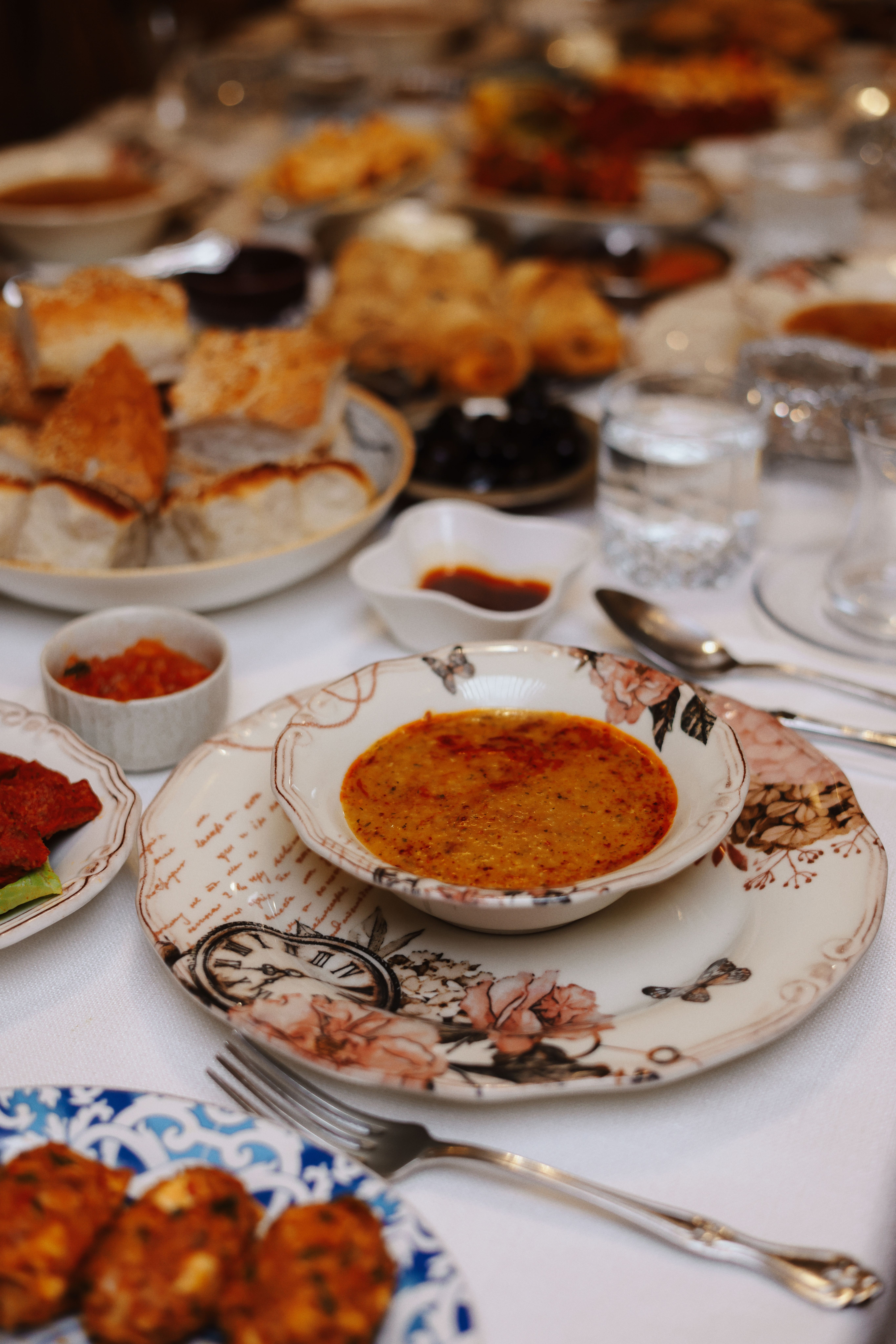 A vibrant Middle Eastern dinner spread featuring soup and appetizers on a beautifully set table.
