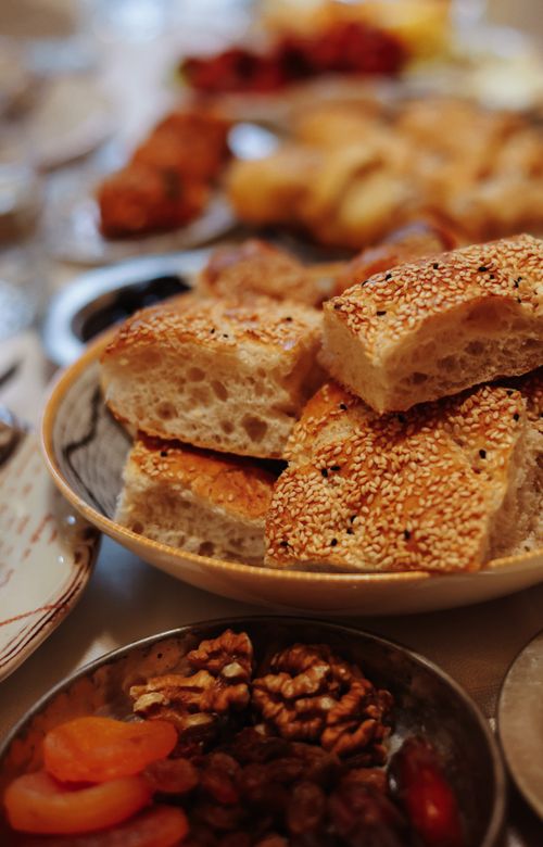 Free Traditional Middle Eastern bread with sesame seeds, served with nuts and dried fruits on a festive table. Stock Photo