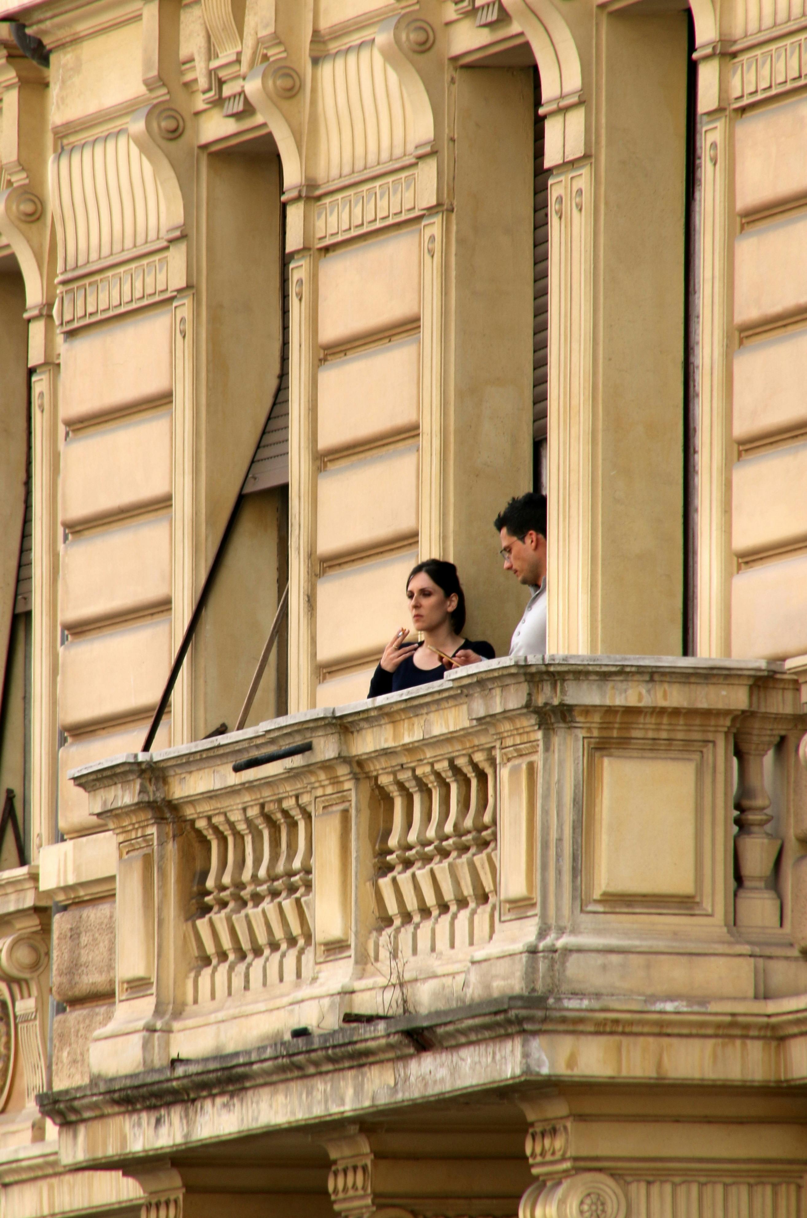 ingyenes Egy pár élvezi a pillanatot egy klasszikus római erkélyen Rómában, Olaszországban. Stockfotó