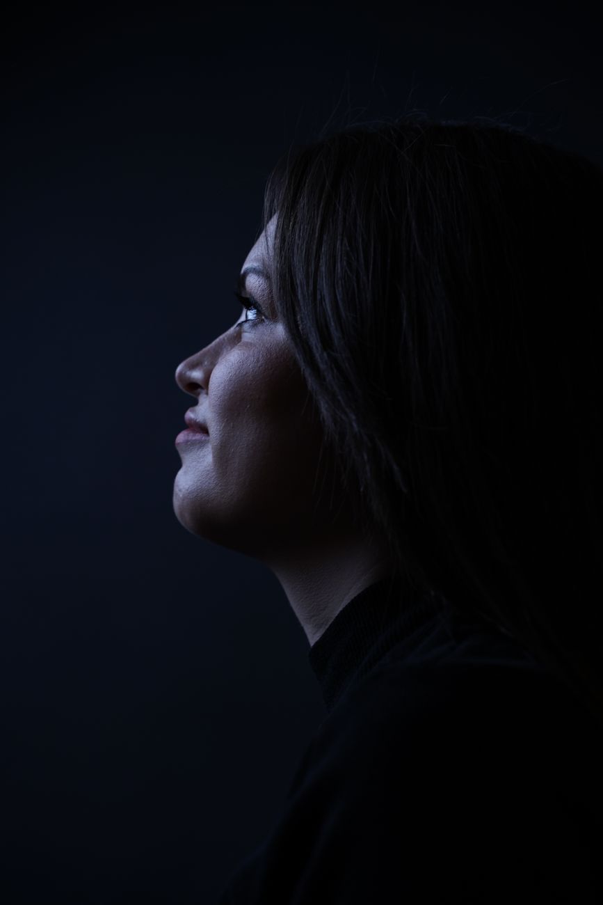 Side profile of a woman in dramatic low key lighting, emphasizing contours.. side, profile, woman