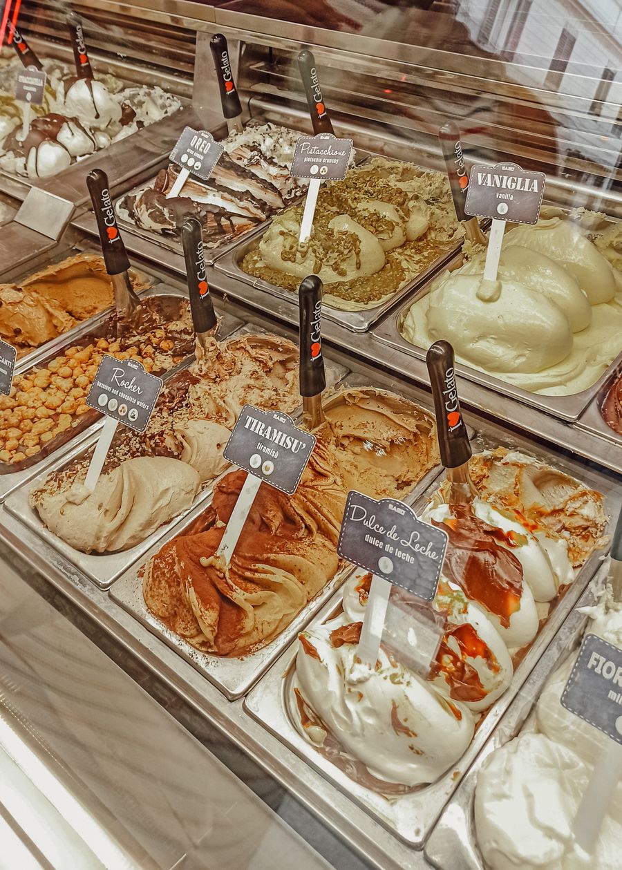 Gelato artizanal italian în vitrină cu arome de fistic, tiramisu și ciocolată