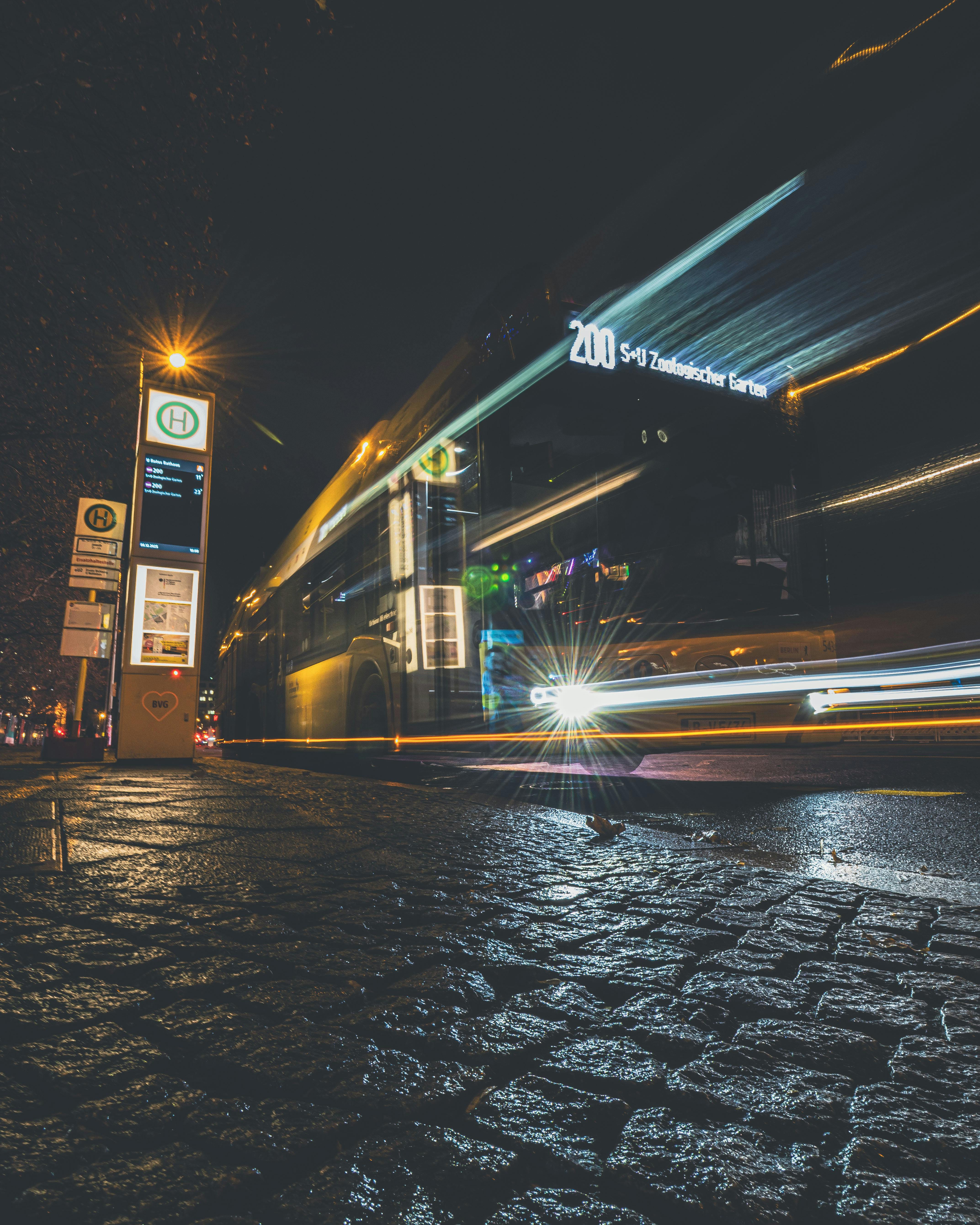 gratis Stadsbus 's nachts gefotografeerd met lichtsporen en een stedelijke omgeving. Stockfoto