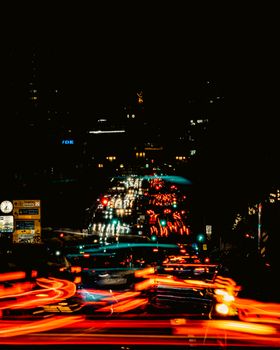 Long exposure city street scene at night showcasing vibrant light trails from vehicles.
