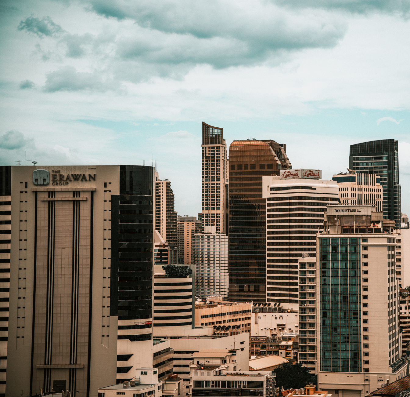 Stunning view of Bangkok's modern skyline featuring towering skyscrapers against a cloudy sky.