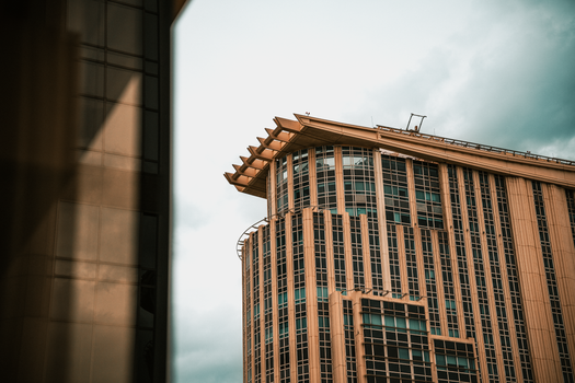 Contemporary building facade with glass and metal in Bangkok, Thailand under overcast sky.