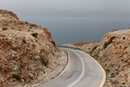 Free Curved mountain road leading to the Dead Sea under an overcast sky in South District, Israel. Stock Photo