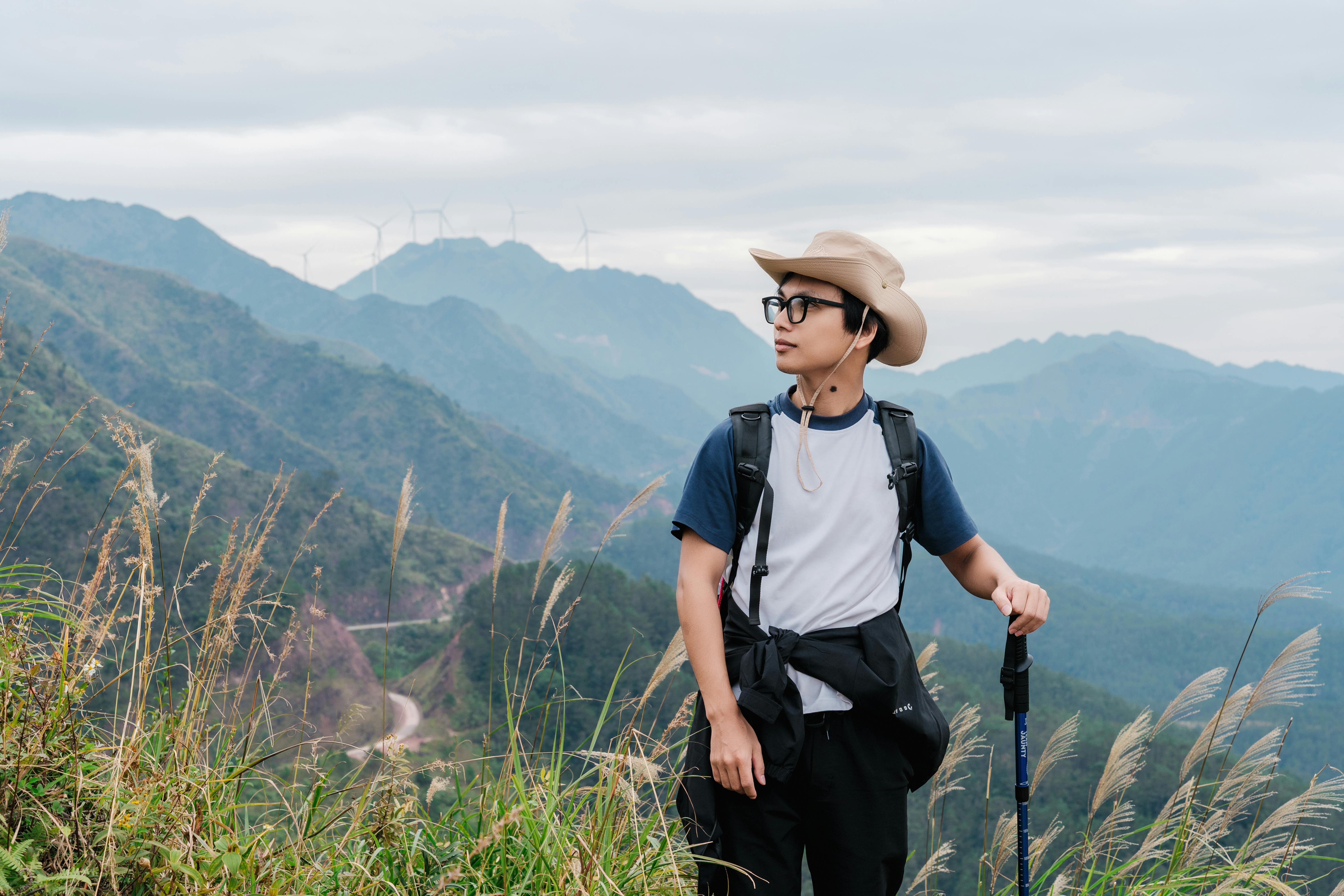 bezplatná Mladý turista si užívá panoramatický výhled na pohoří Quang Ninh s větrnými turbínami v pozadí. Základová fotografie