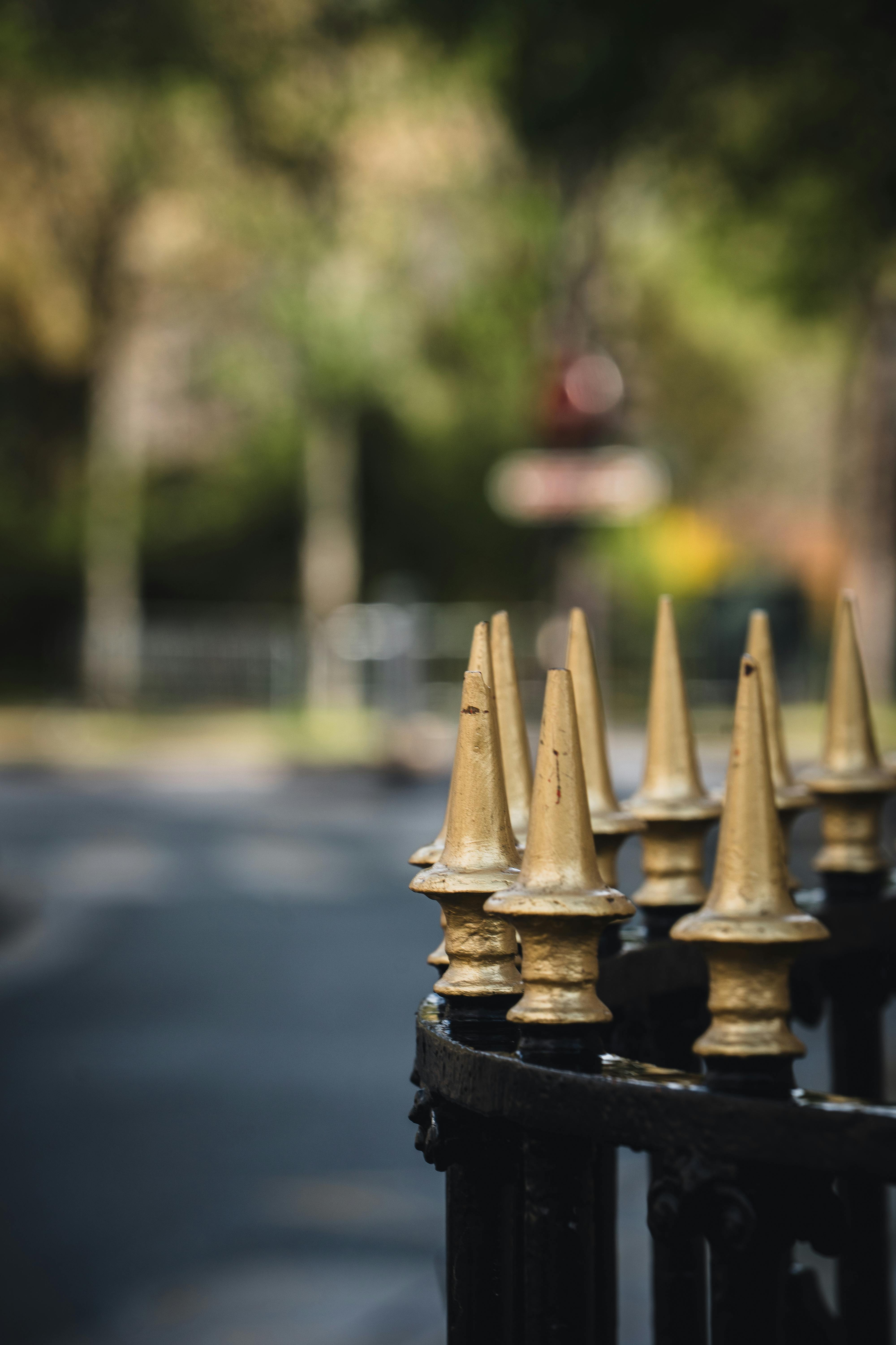 ingyenes Arany vaskerítéstüskék közeli képe elmosódott utcai háttérrel. Stockfotó