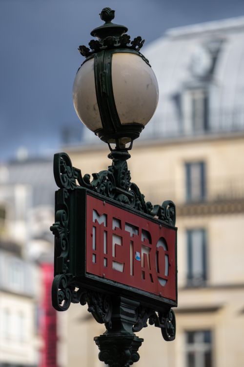 Free Art Nouveau Metro sign in Paris with elegant lamp post, capturing classic French urban design. Stock Photo