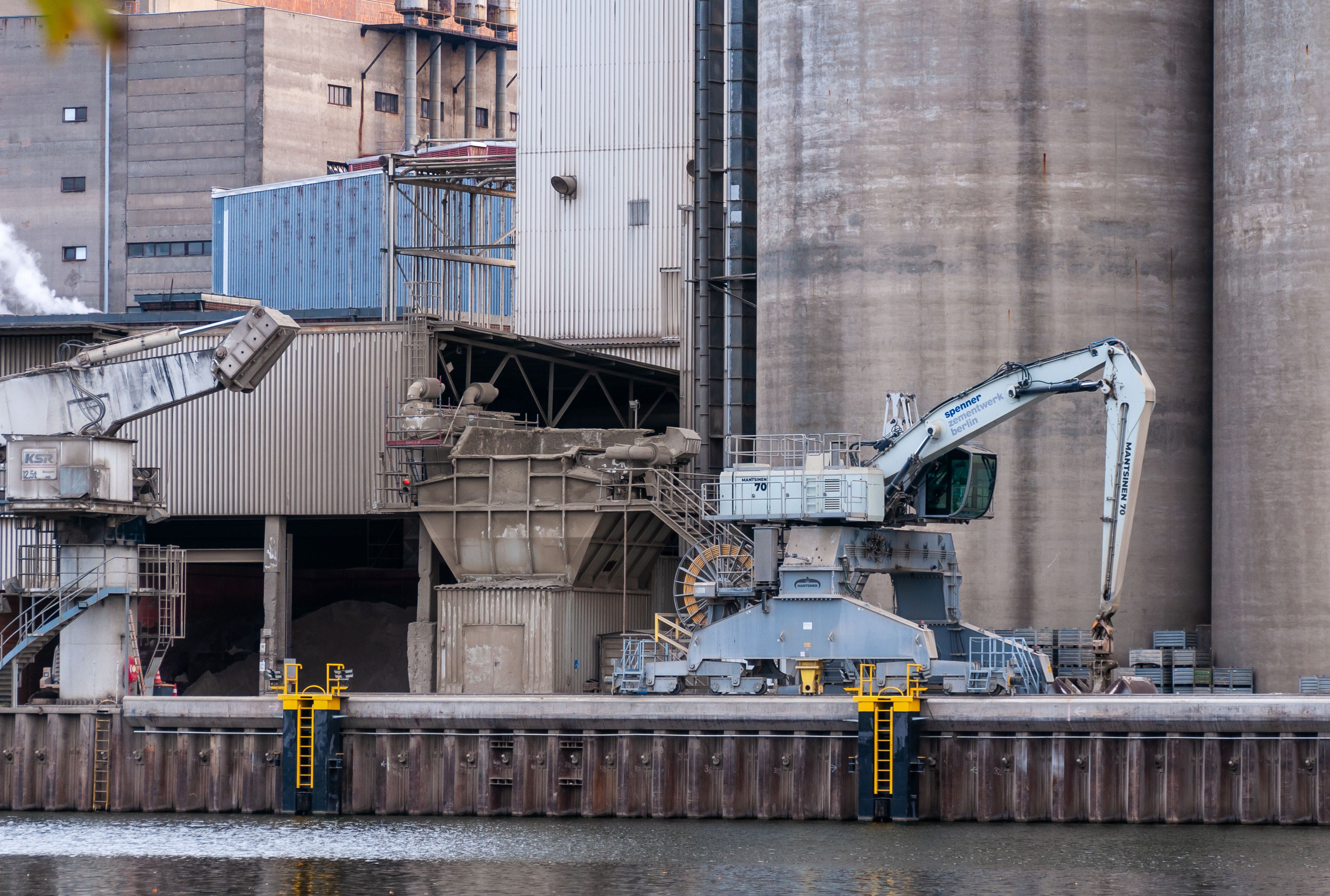 View of industrial machinery operating at a dockside facility with large silos.