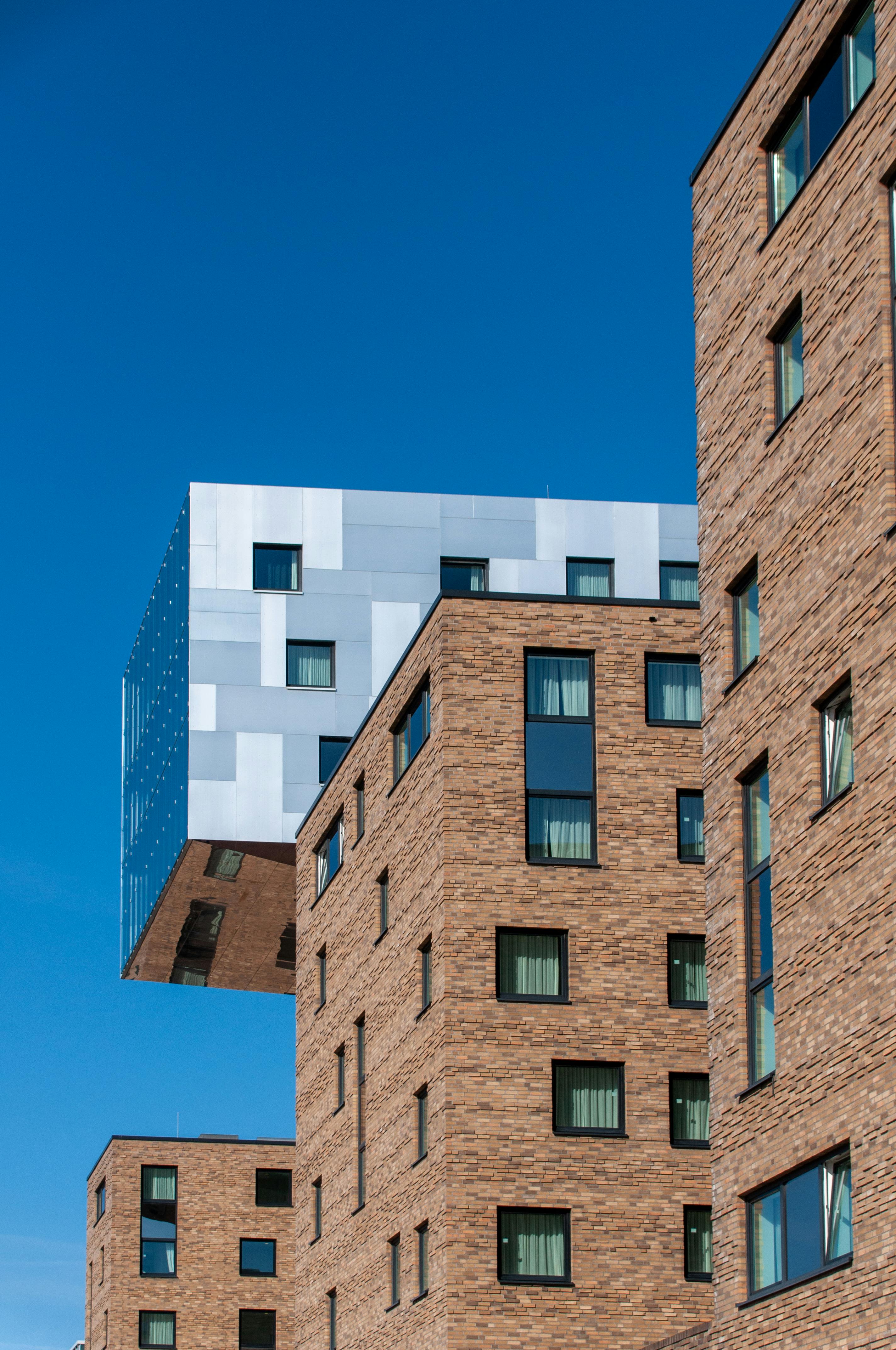 Gratis Edificios contemporáneos con fachada de ladrillo y metal contra un cielo azul despejado, que muestran la arquitectura moderna. Foto de stock