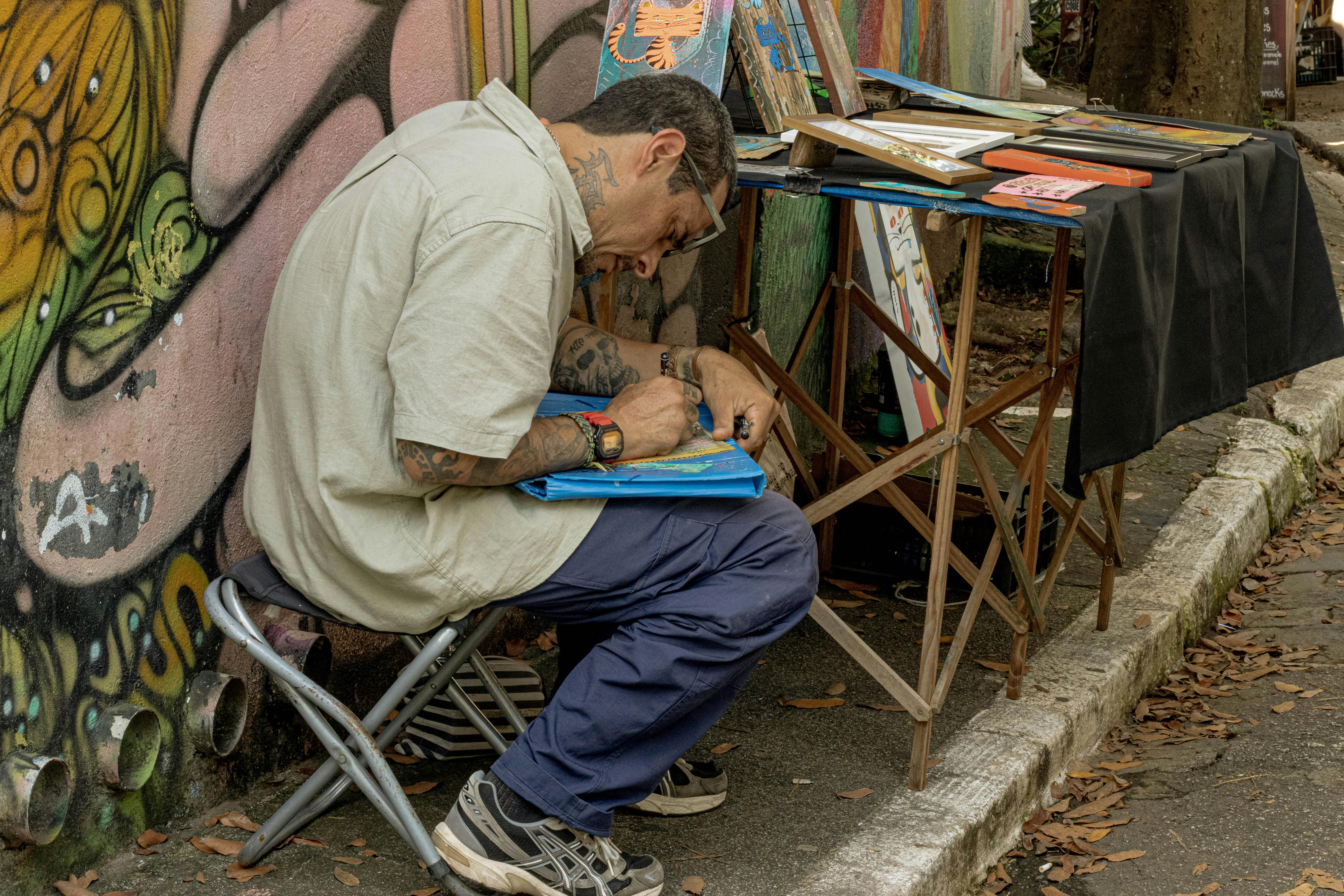gratis Straatkunstenaar die zich richt op het creëren van levendige kunst op een stadsstoep en zo stedelijke creativiteit tentoonstelt. Stockfoto